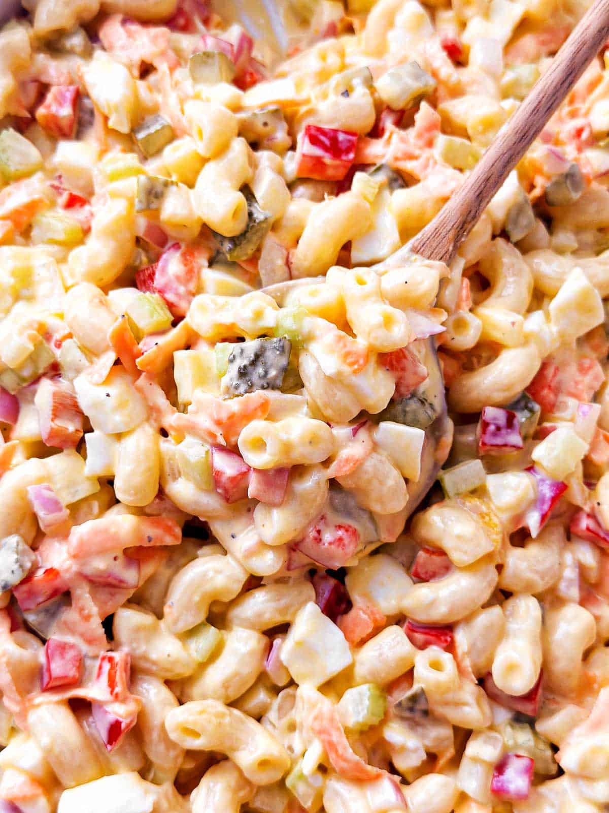overhead close up photos of wooden spoon scooping up macaroni salad