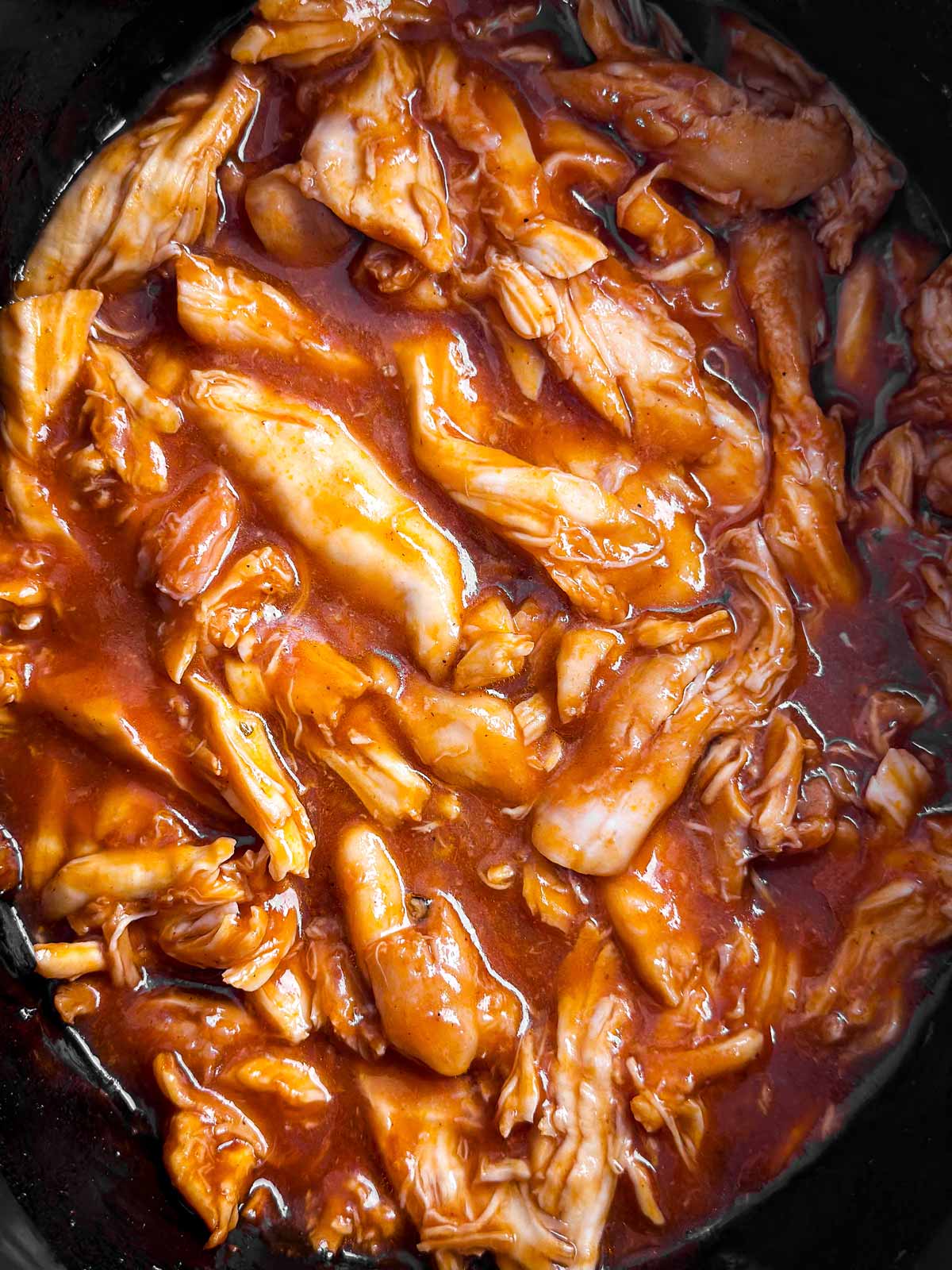 overhead close up view of pulled bbq chicken in slow cooker crock