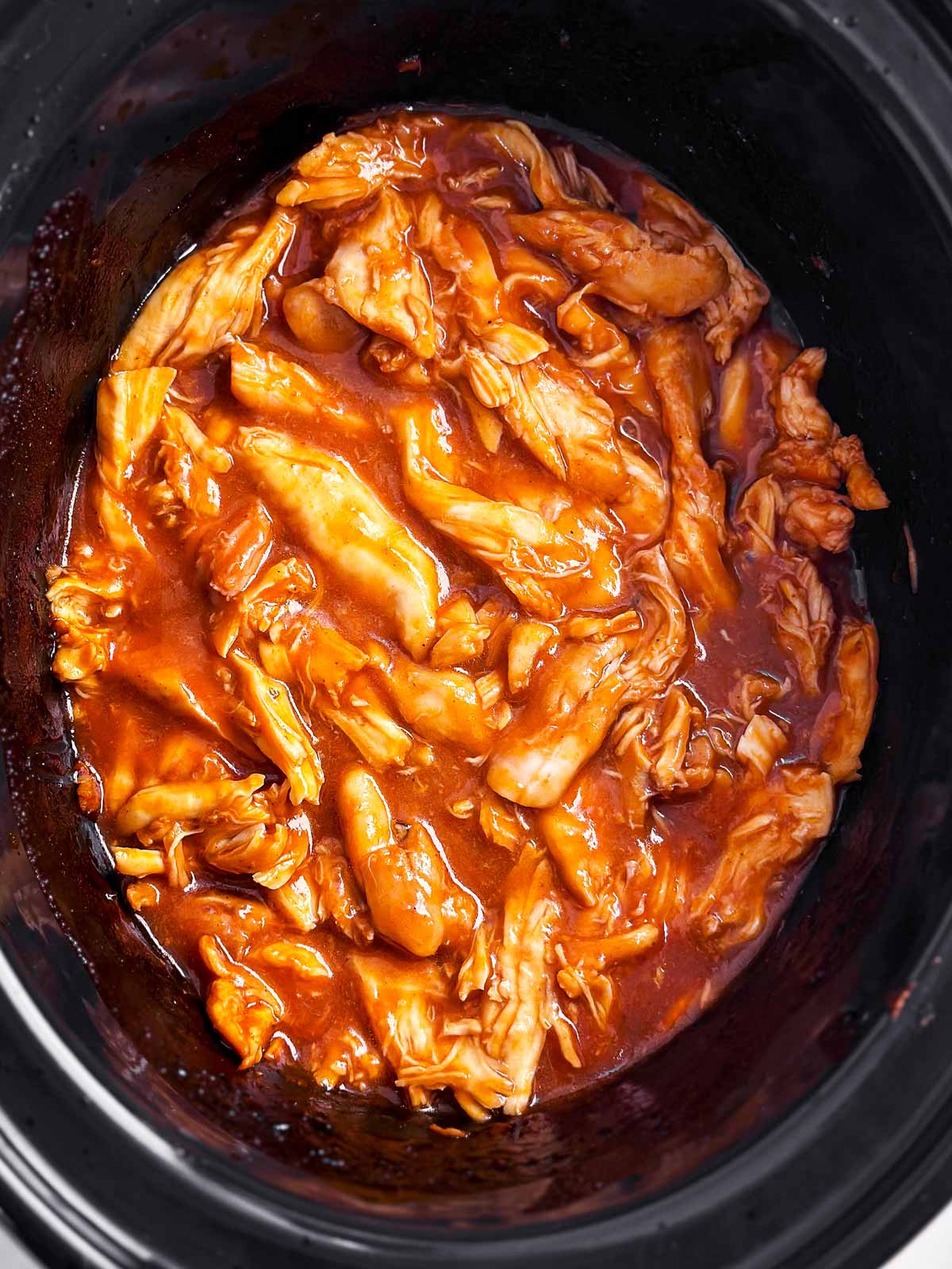 overhead view of pulled bbq chicken in crock