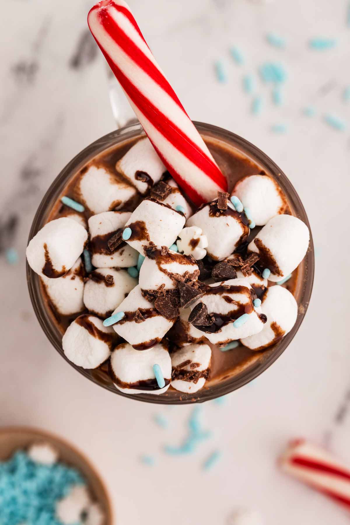 overhead view of photo chocolate with marshmallows, sprinkles and candy cane