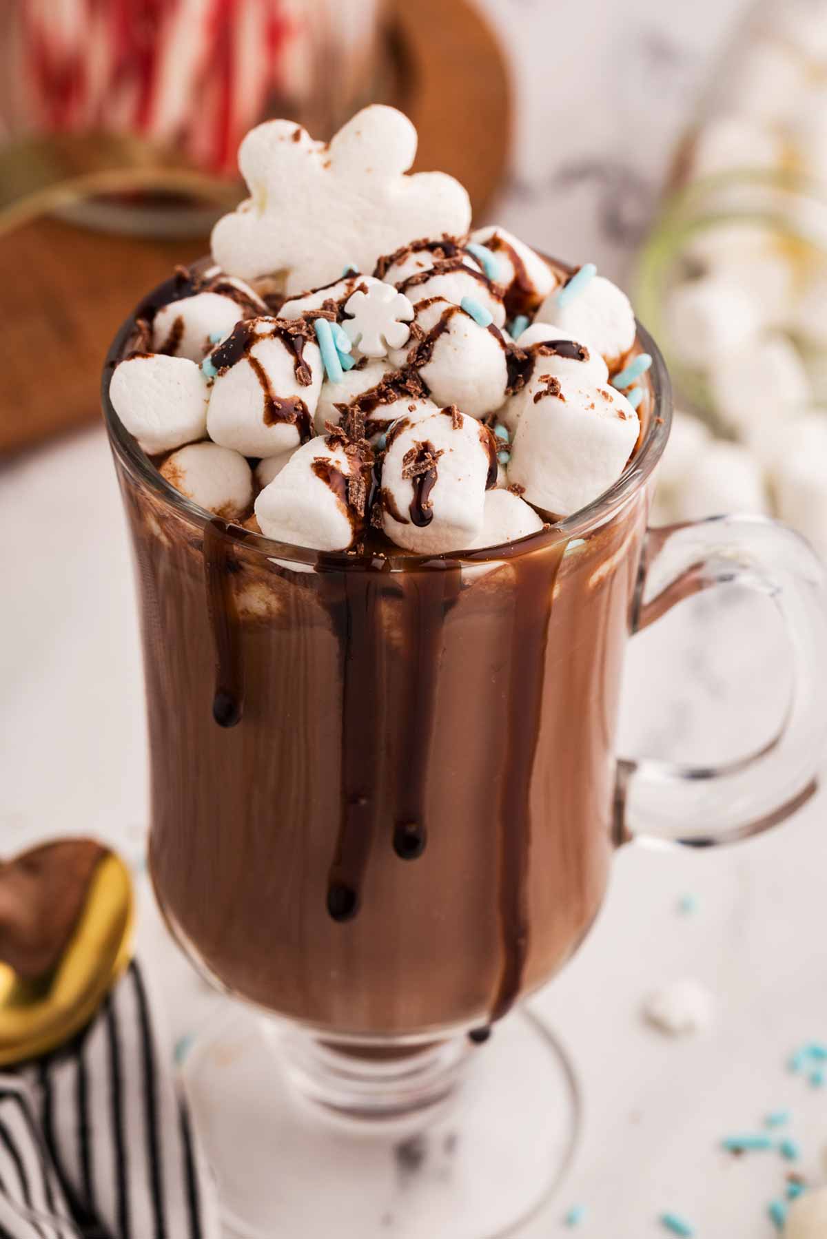 frontal close up view of glass mug filled with hot chocolate and toppings