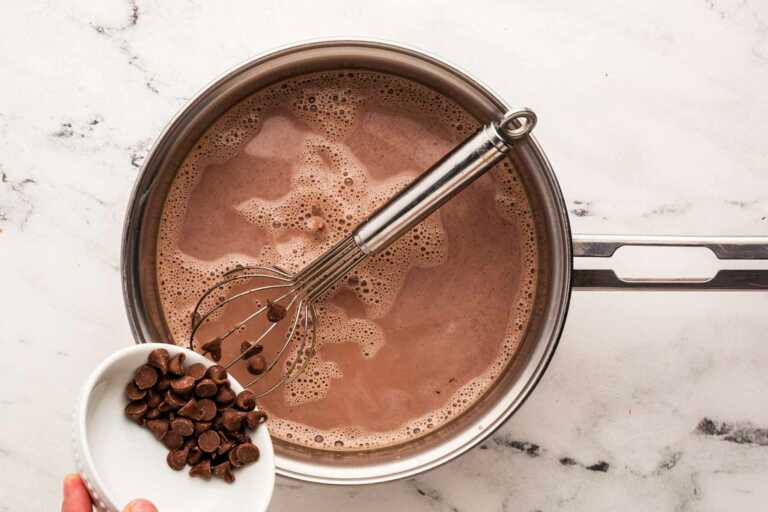 chocolate chips dropping into hot chocolate in saucepan