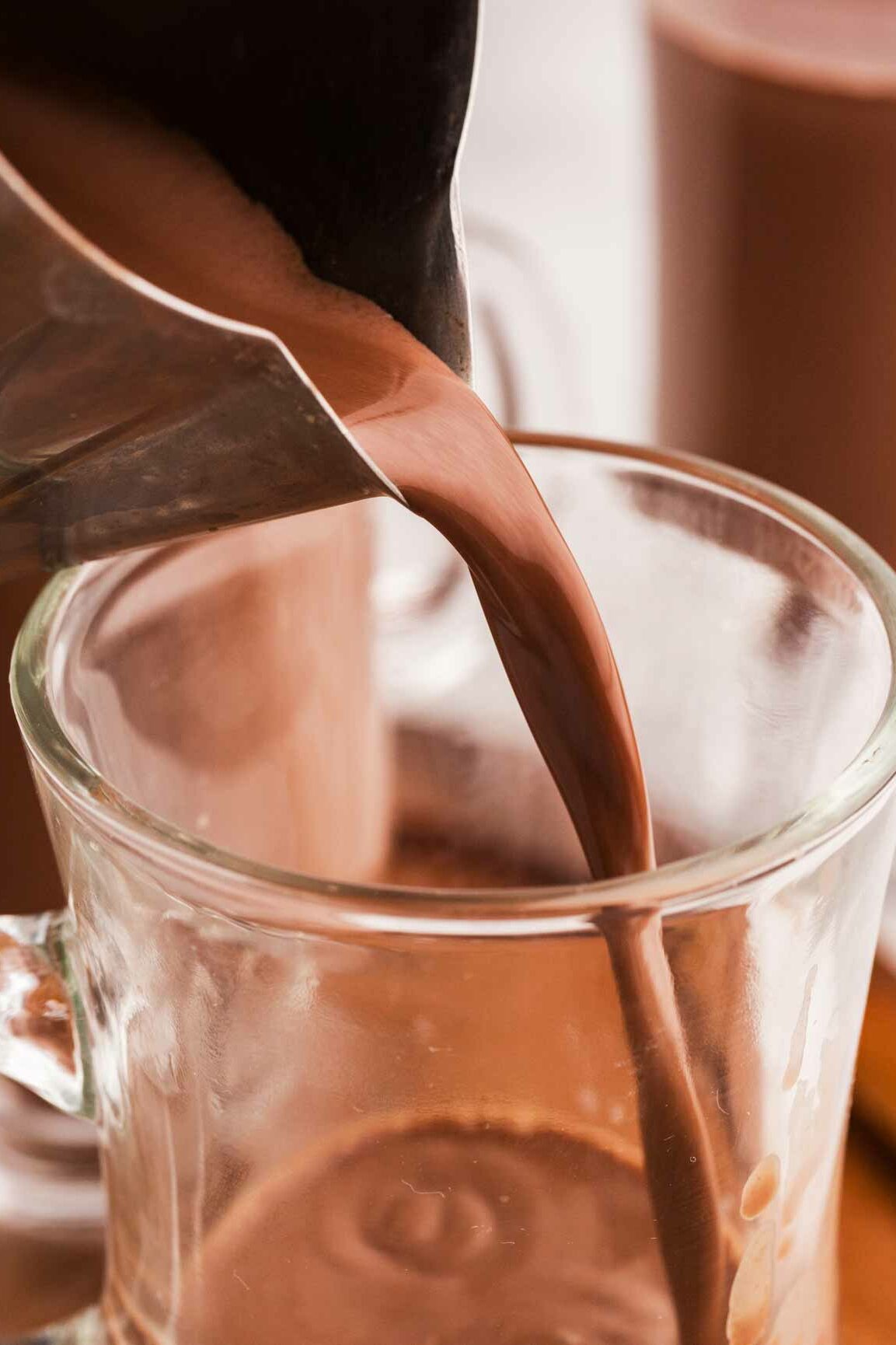 hot chocolate pouring into glass mug