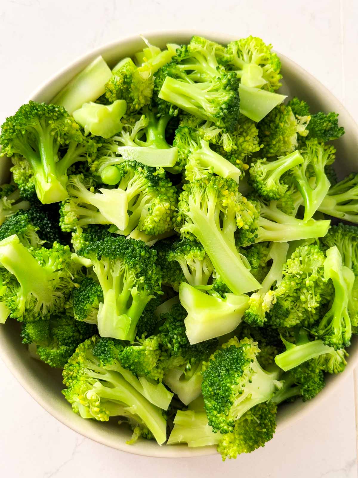 overhead view of cooked broccoli in white bowl