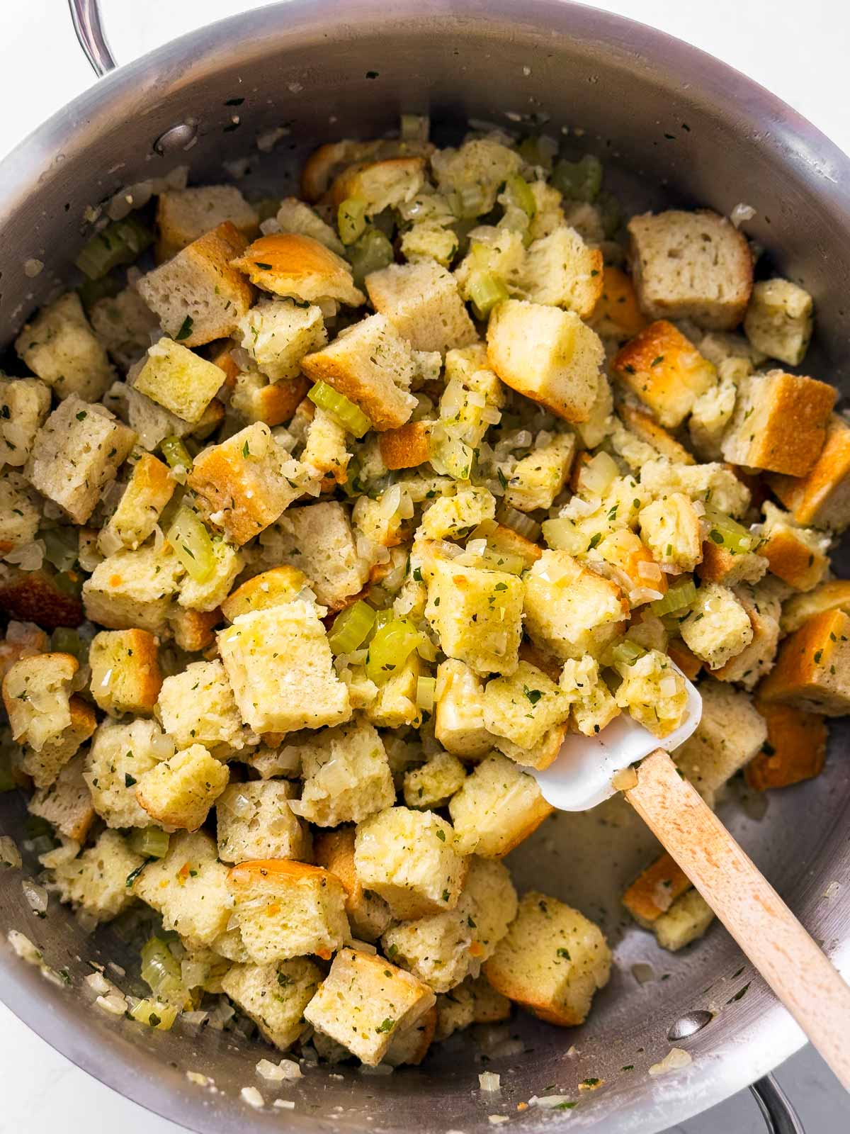 uncooked stuffing mixture in large pan with rubber spatula