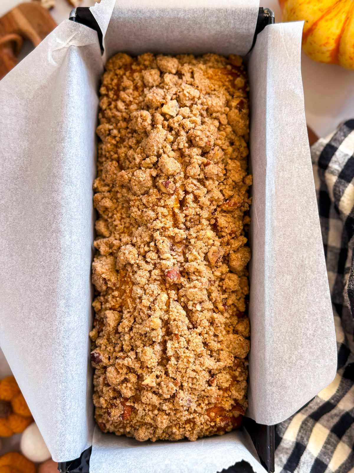 overhead view of baked streusel pumpkin bread in lined loaf pan