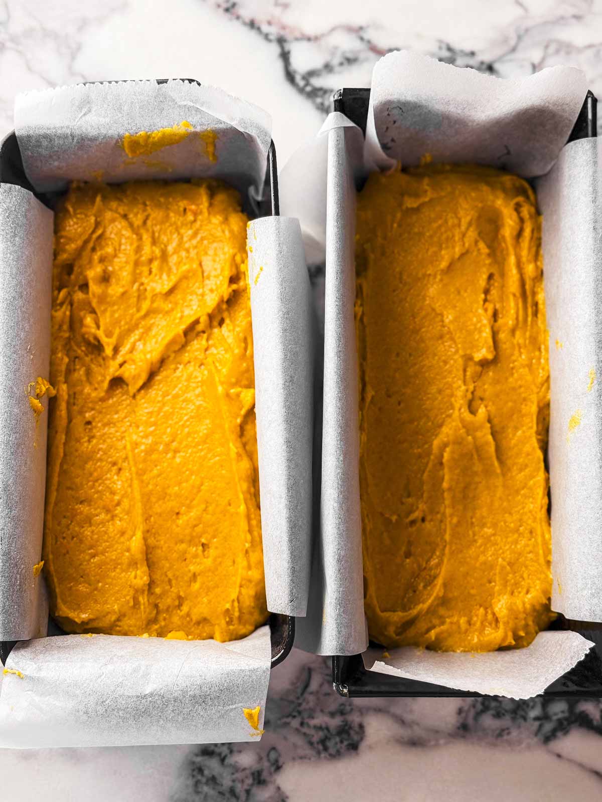 overhead view of pumpkin bread batter in two loaf pans