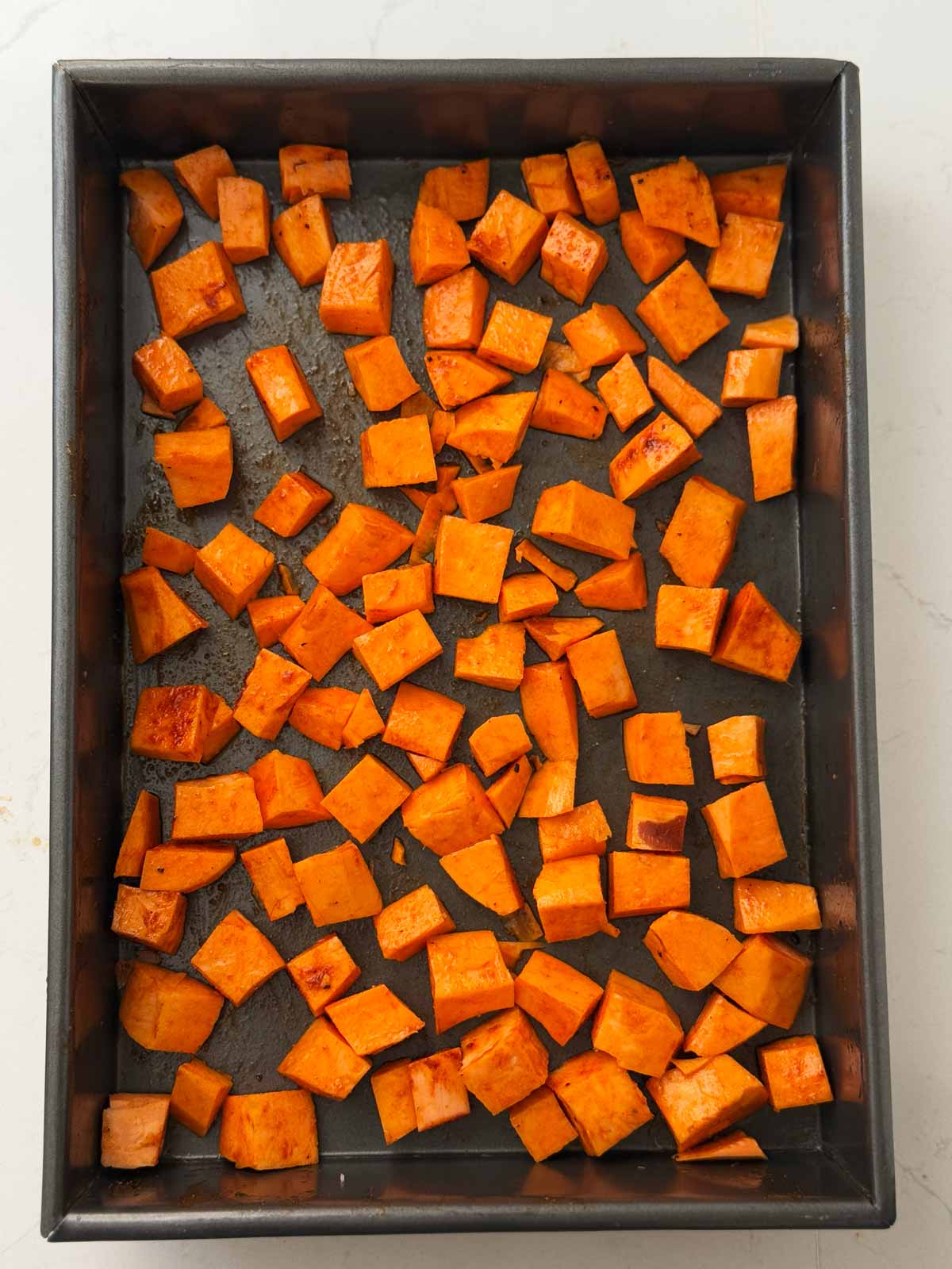 overhead view of savory seasoned sweet potatoes on sheet pan