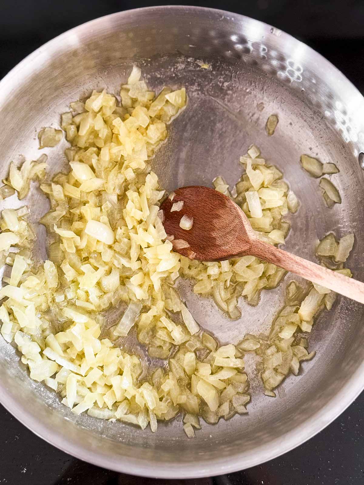 overhead view of sautéed onion and garlic in saucepan