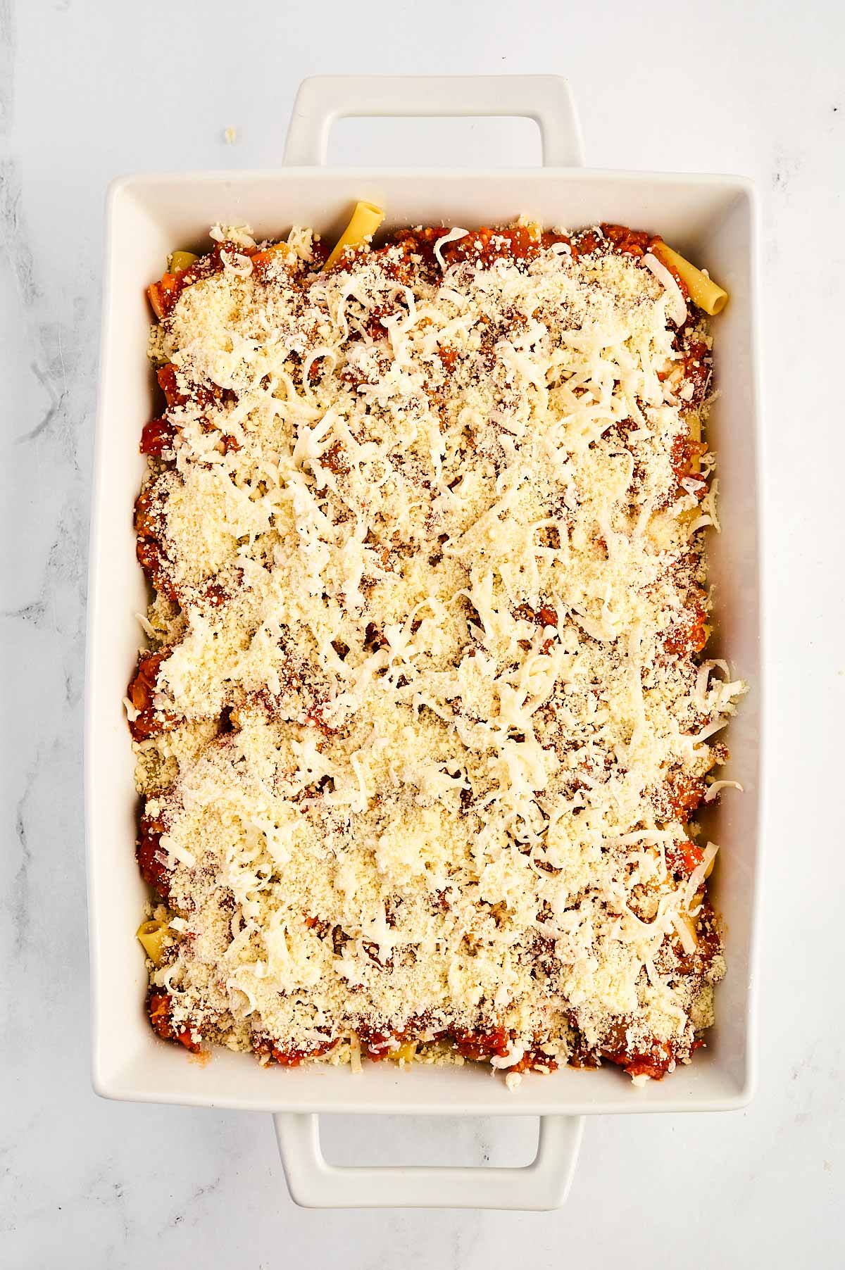 overhead view of unbaked baked ziti in white casserole dish