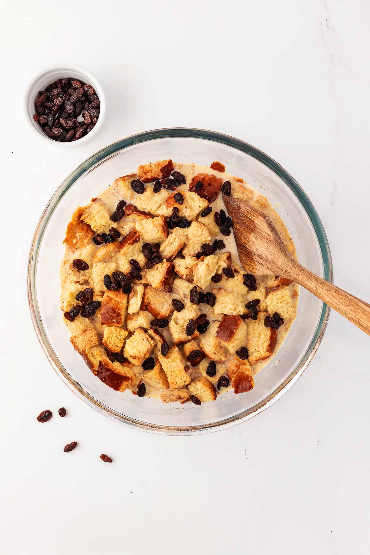 overhead view of bread pudding mix in bowl with raisins