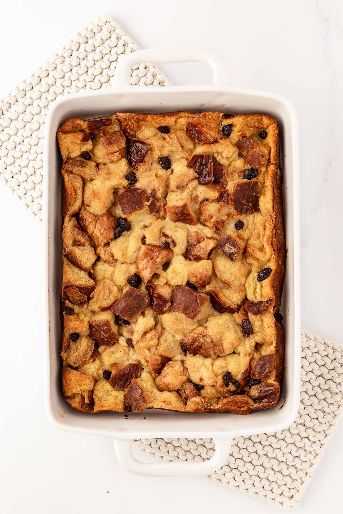 overhead view of baked bread pudding in white casserole dish