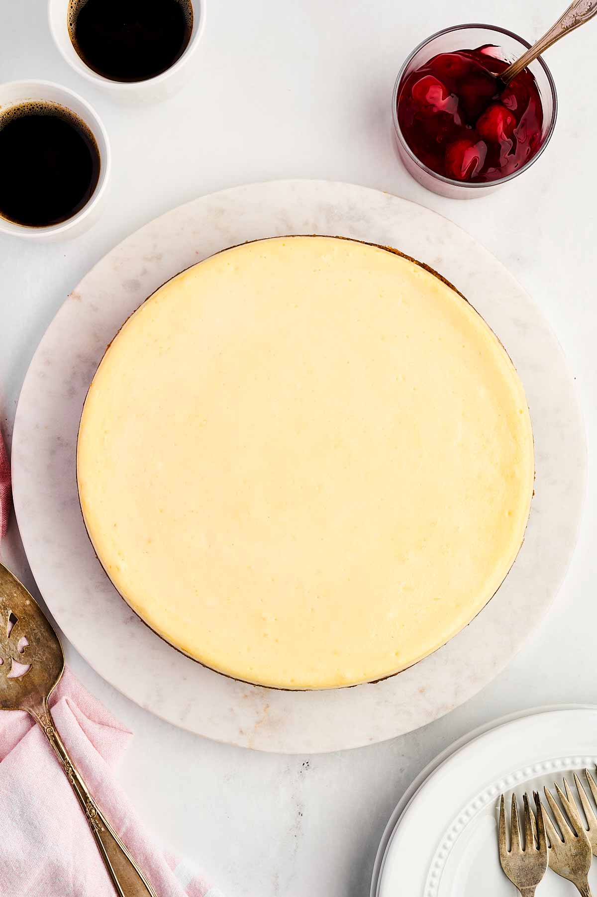 overhead view of baked cheesecake on marble serving platter