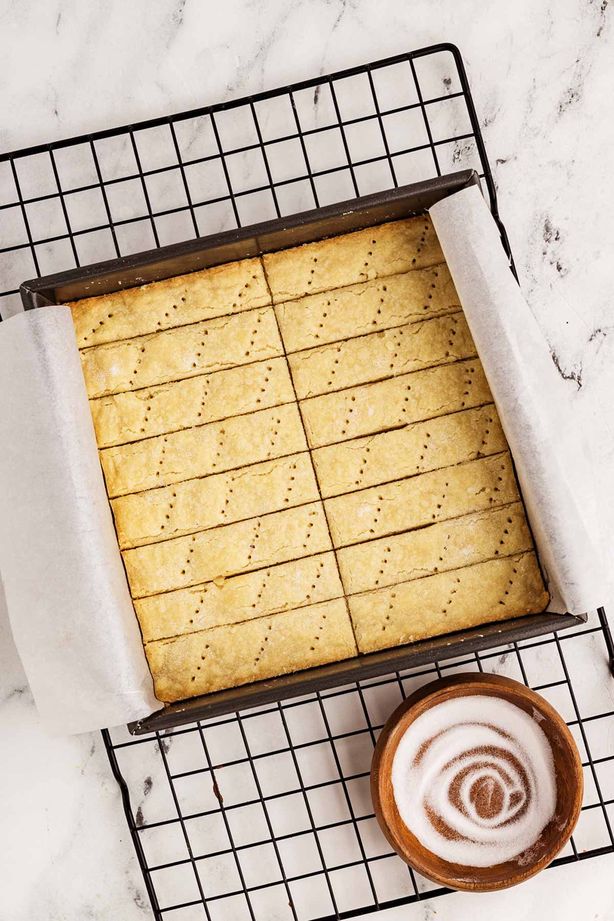 overhead view of pan with baked shortbread cookies on wire rack