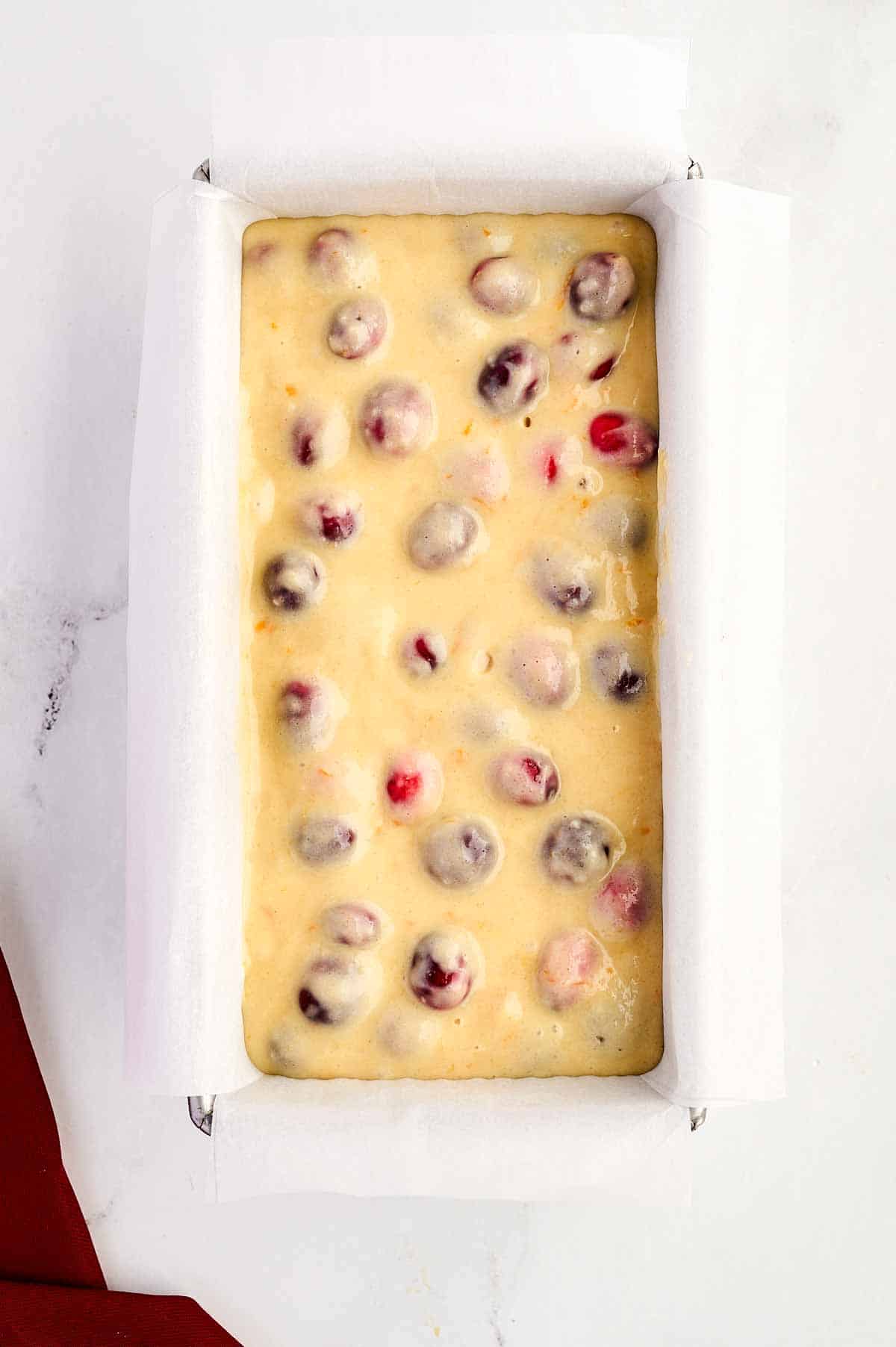 overhead view of unbaked cranberry orange bread in loaf pan