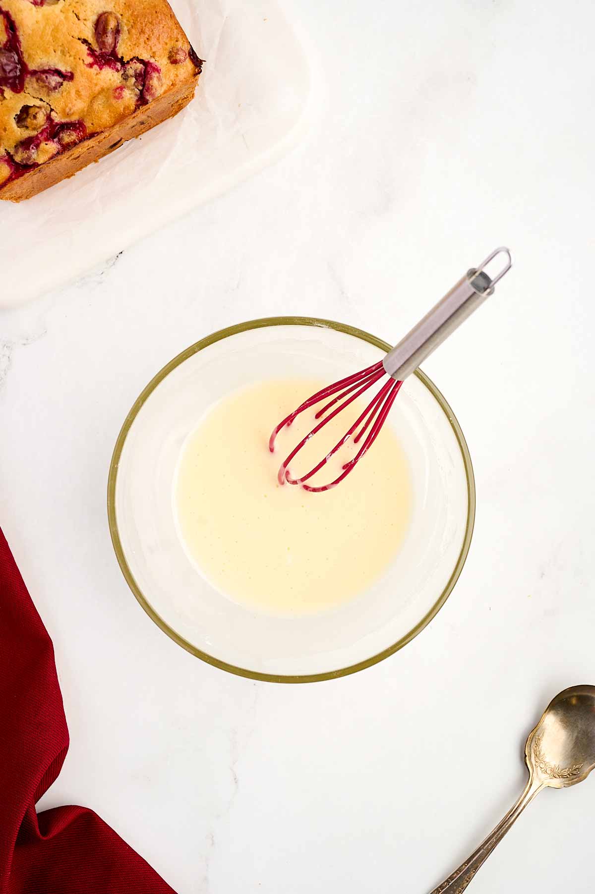 overhead view of glaze in small glass bowl with mini whisk