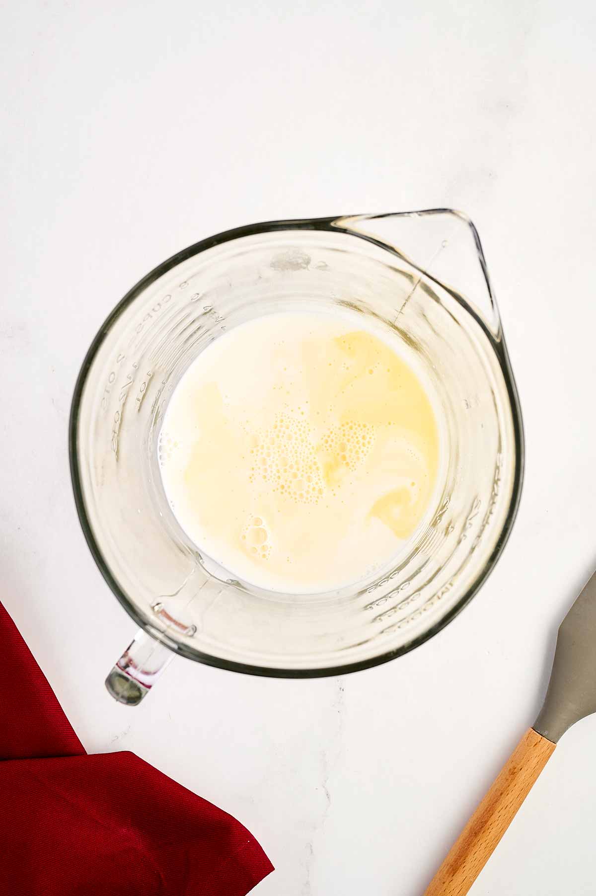 overhead view of milk and orange juice in glass bowl