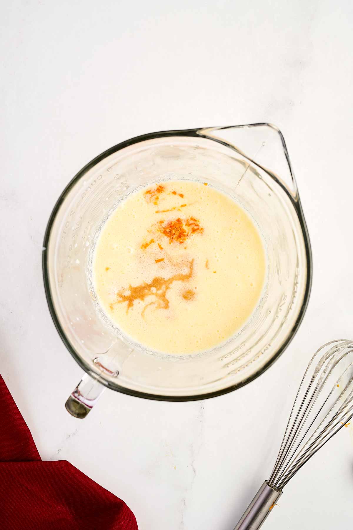 overhead view of eggs in bowl with milk