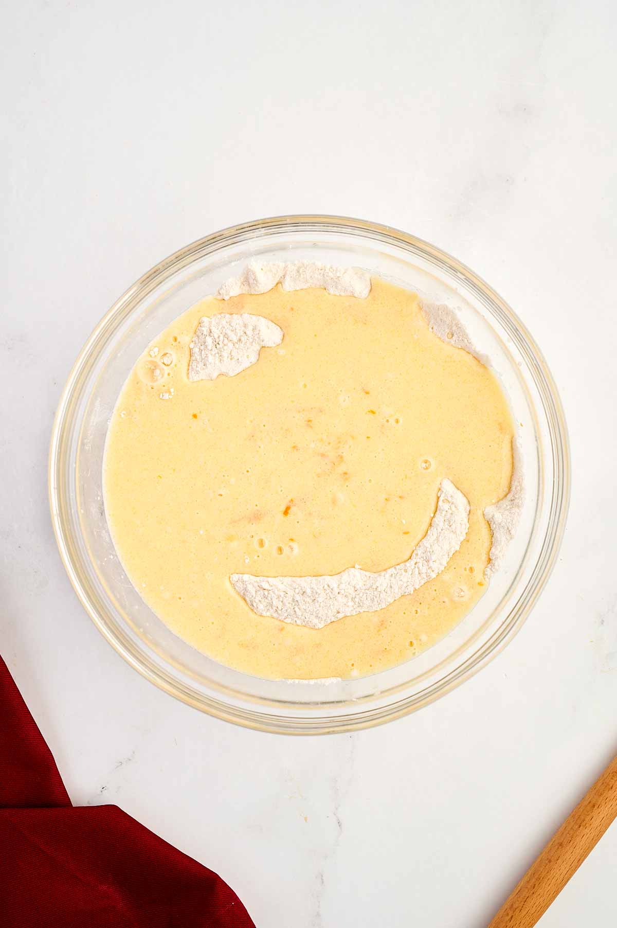 overhead view of wet and dry cake ingredients in glass bowl