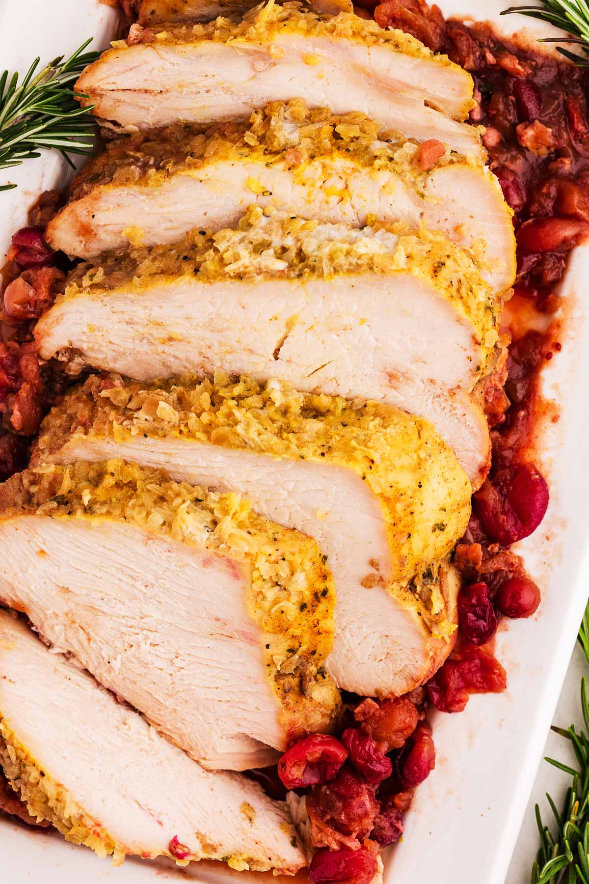 overhead view of sliced turkey breast slices on top of cranberry sauce