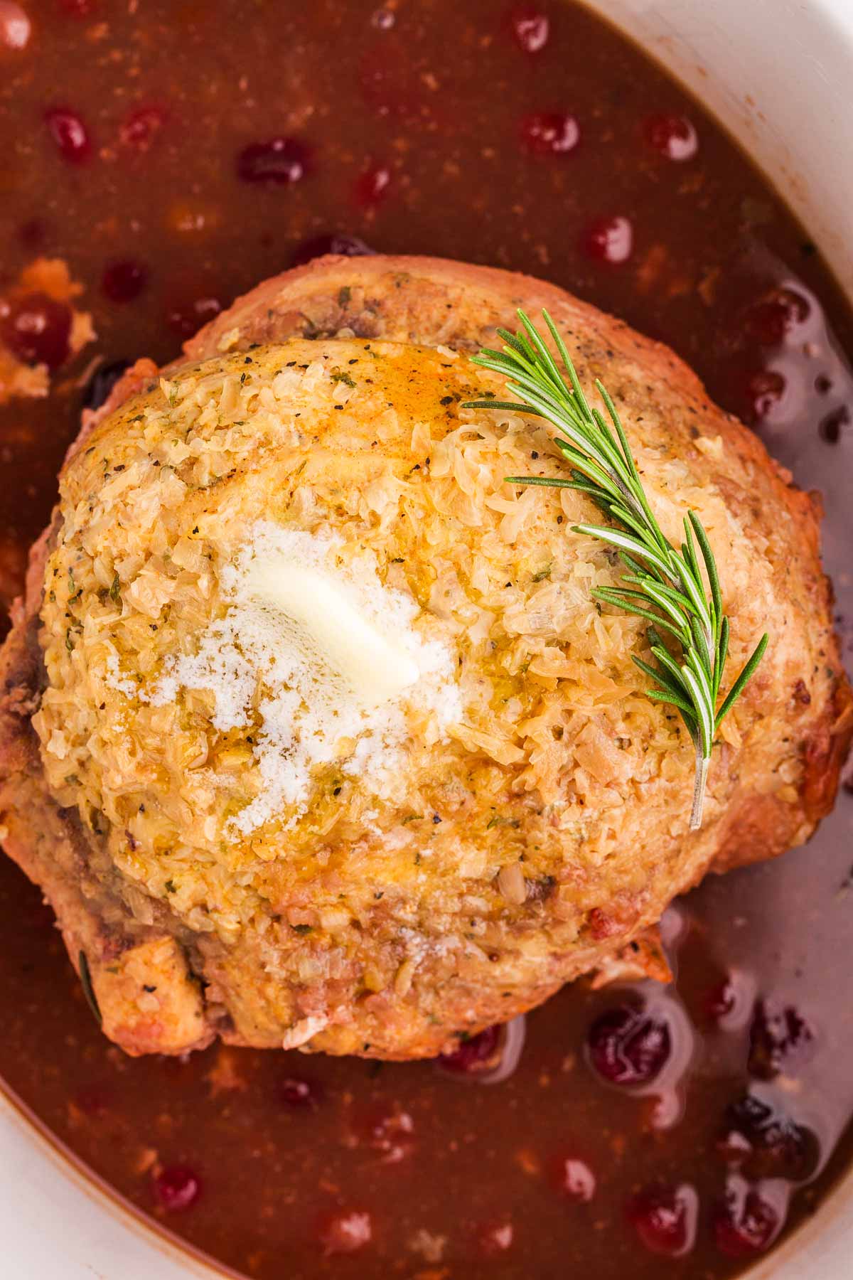 close up shot of turkey breast in slow cooker with cranberry sauce