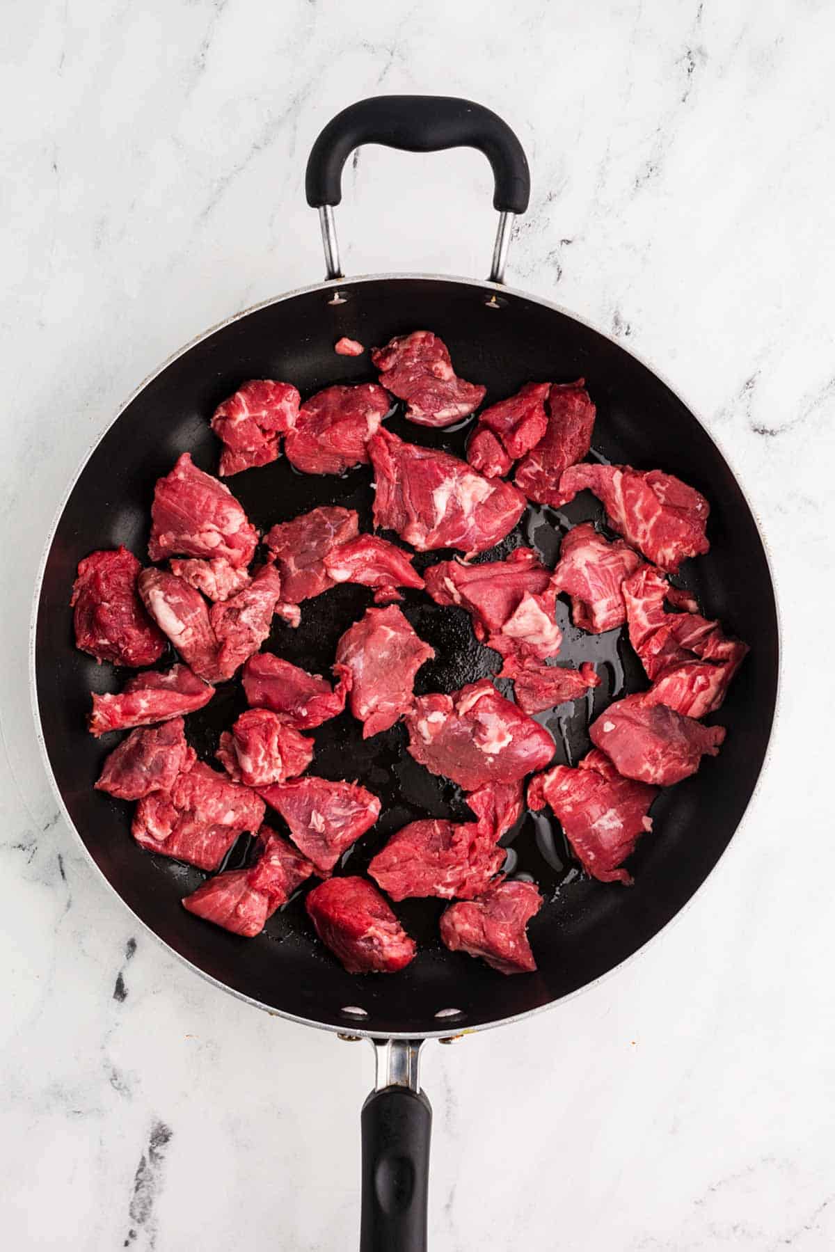 overhead view of raw beef in skillet