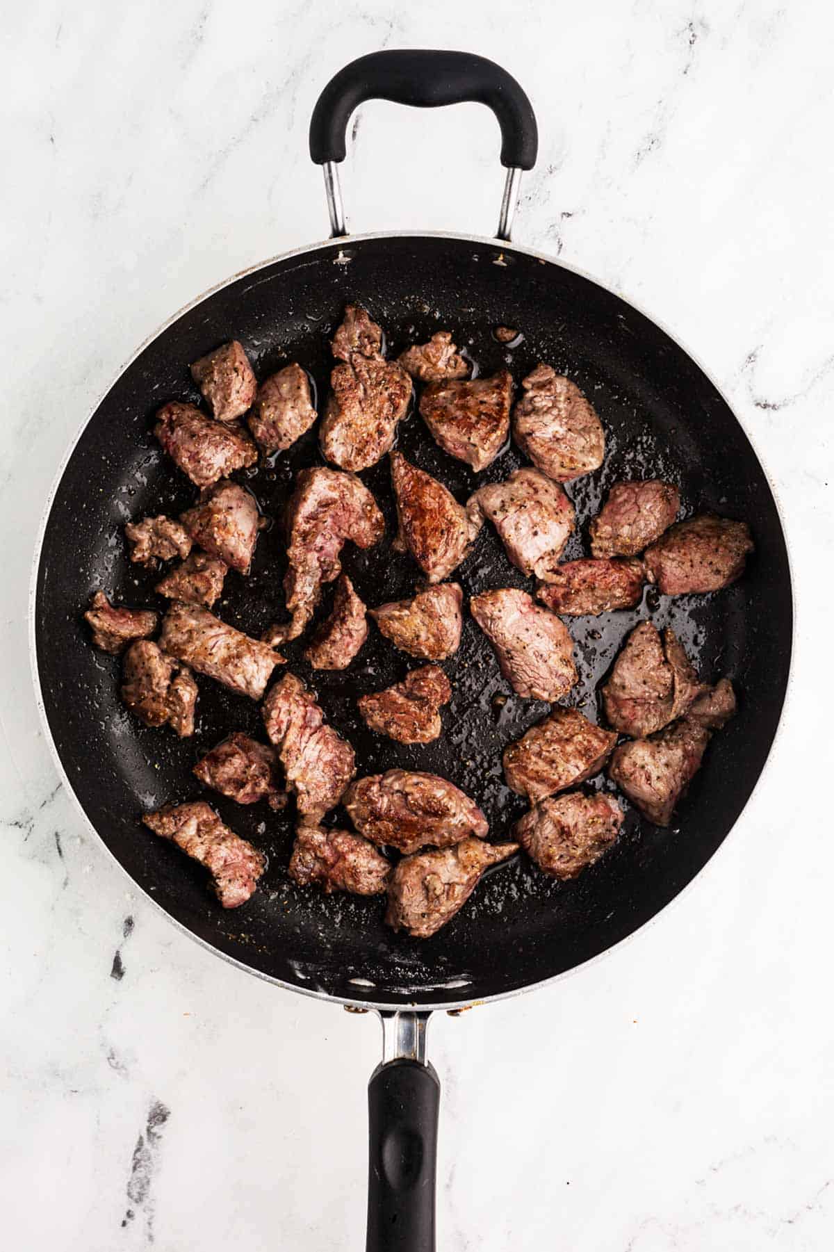 overhead view of seared beef in skillet