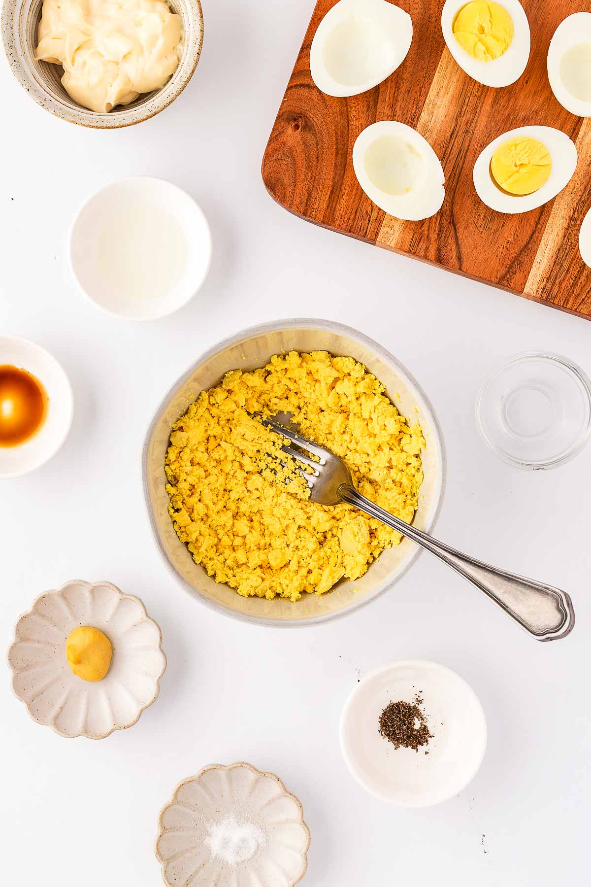 overhead view of mashed yolks in white bowl