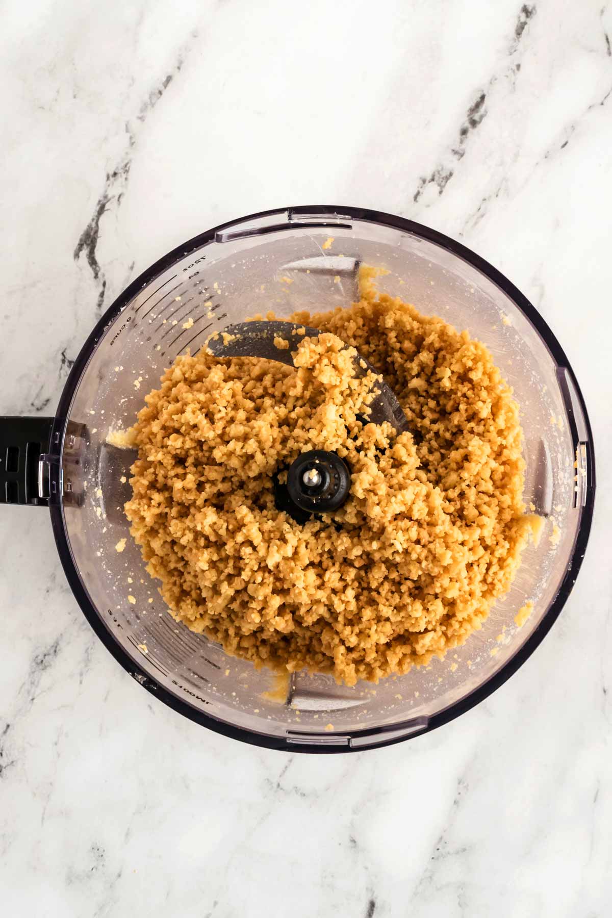 overhead view of shortbread crumbs in food processor bowl