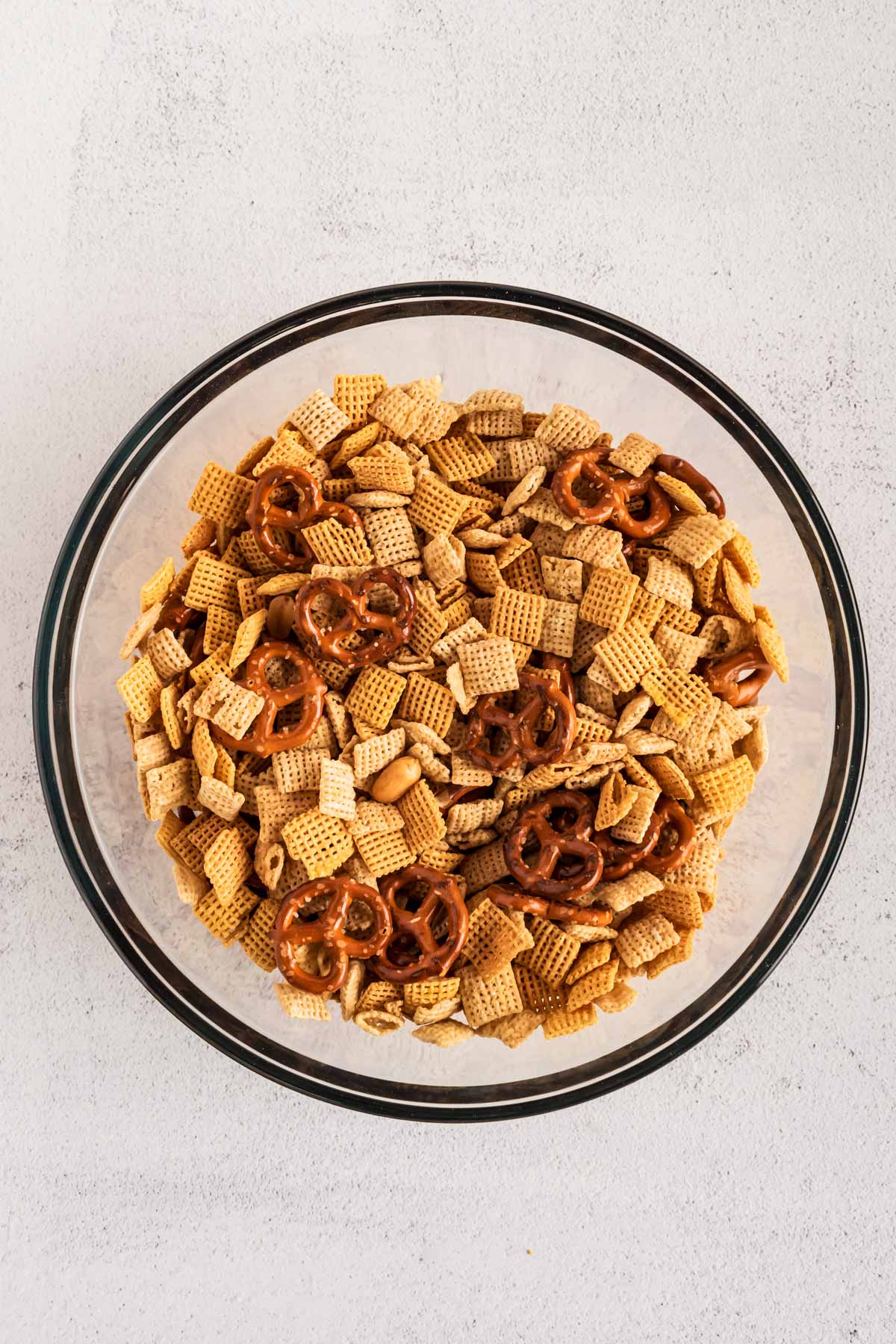 overhead view of dry ingredients to make reindeer chow in glass bowl