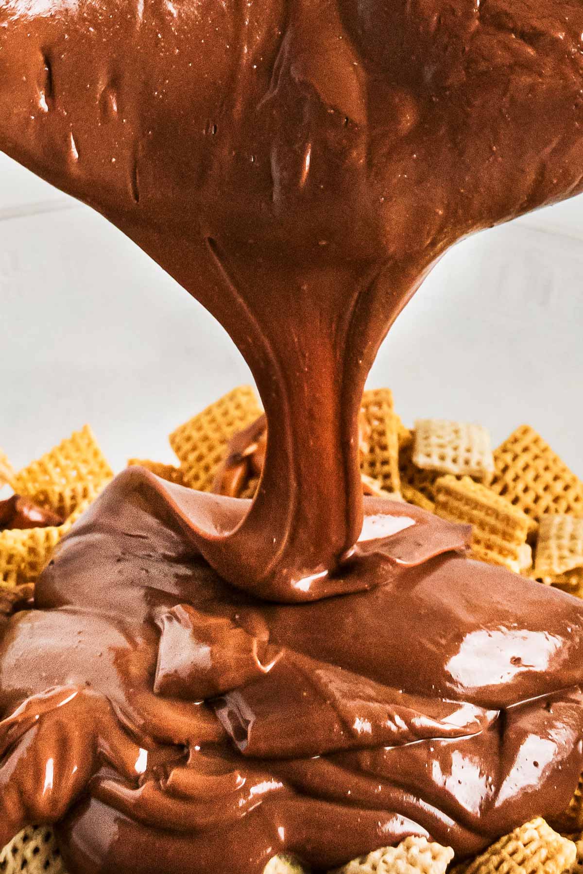 melted chocolate pouring over Chex cereal