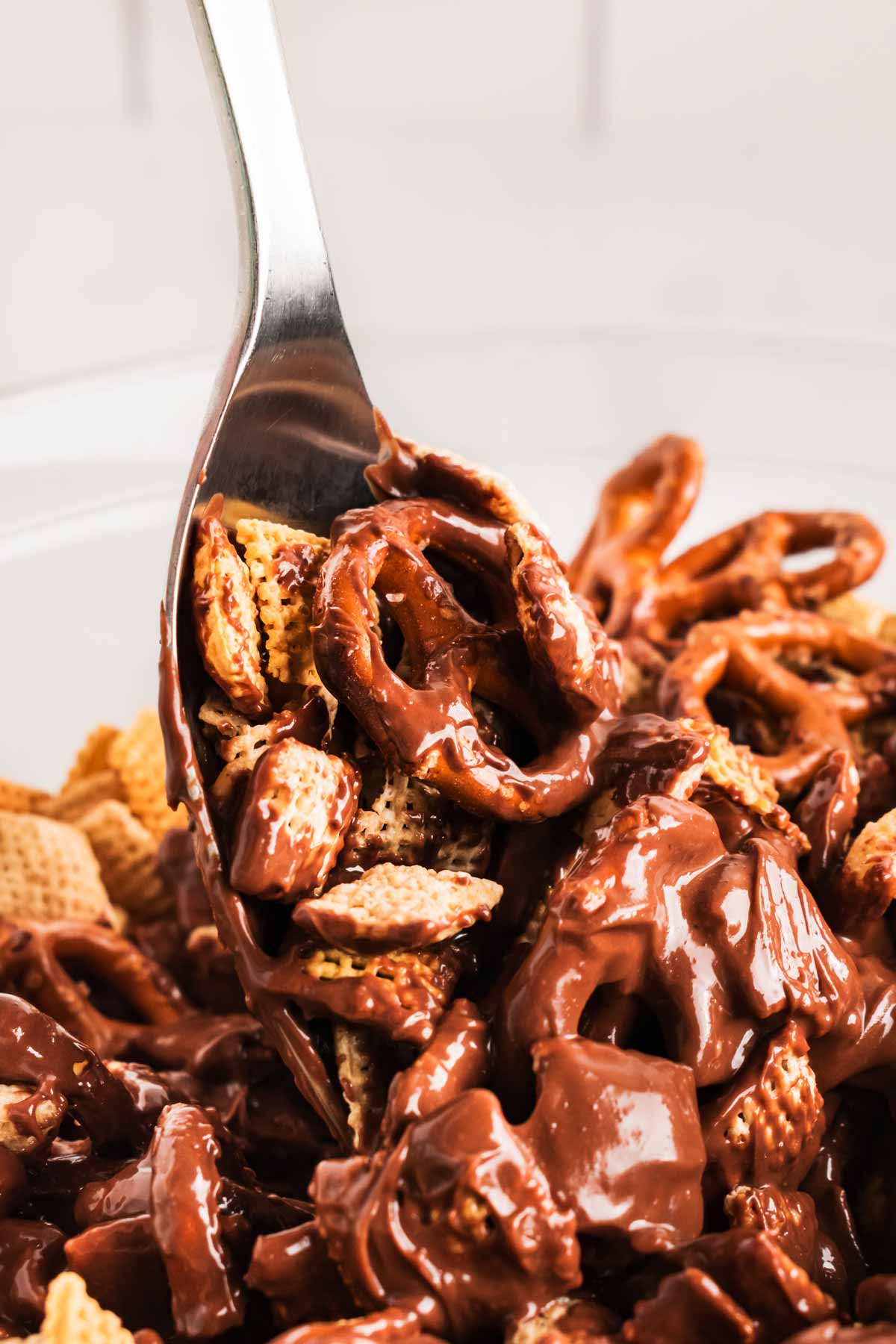 close up view of spoon stirring reindeer chow mixture