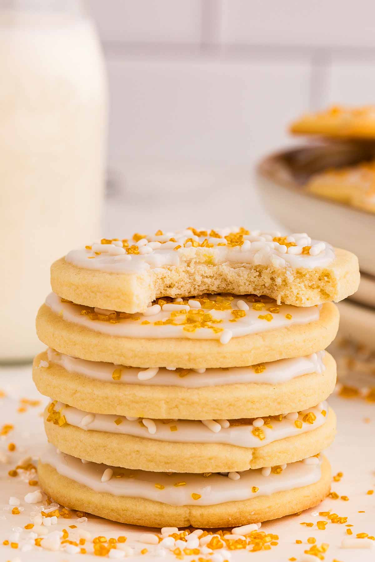 frontal view of stacked sugar cookies with the top one having a bite taken out