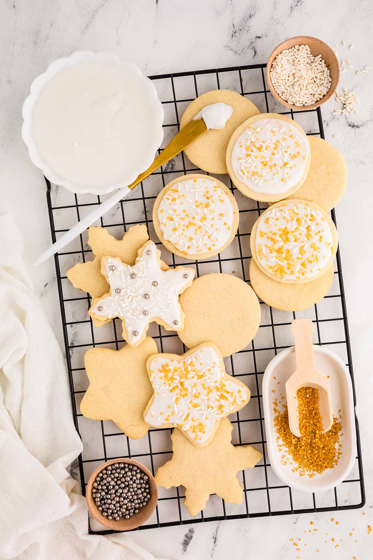 overhead view of white, gold and silver decorated sugar cookies on wire rack