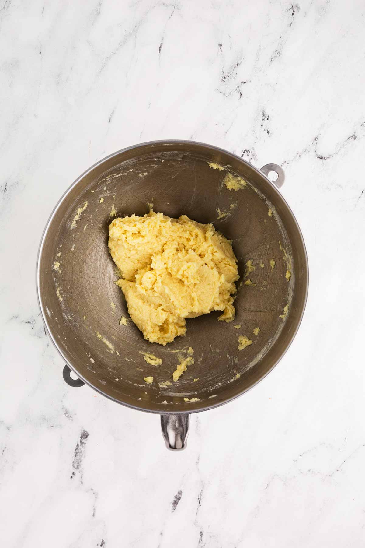 overhead view of creamed butter and sugar and egg in stand mixer bowl