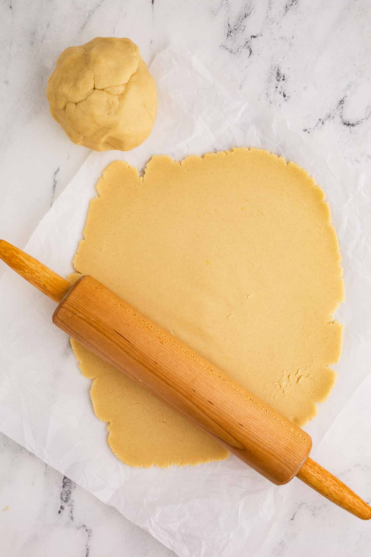 overhead view of rolled out sugar cookie dough with rolling pin