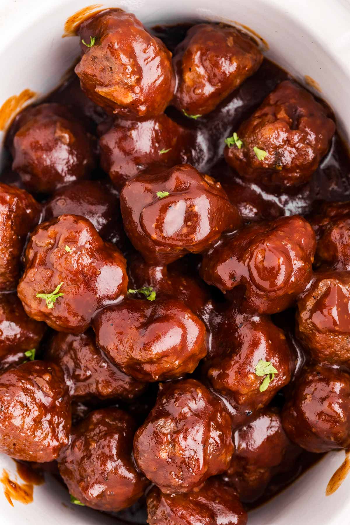 overhead close up view of bbq meatballs in white crock of slow cooker