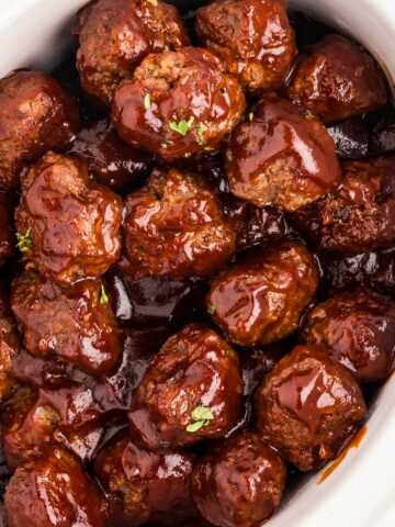 overhead close up view of bbq meatballs in white crock of slow cooker