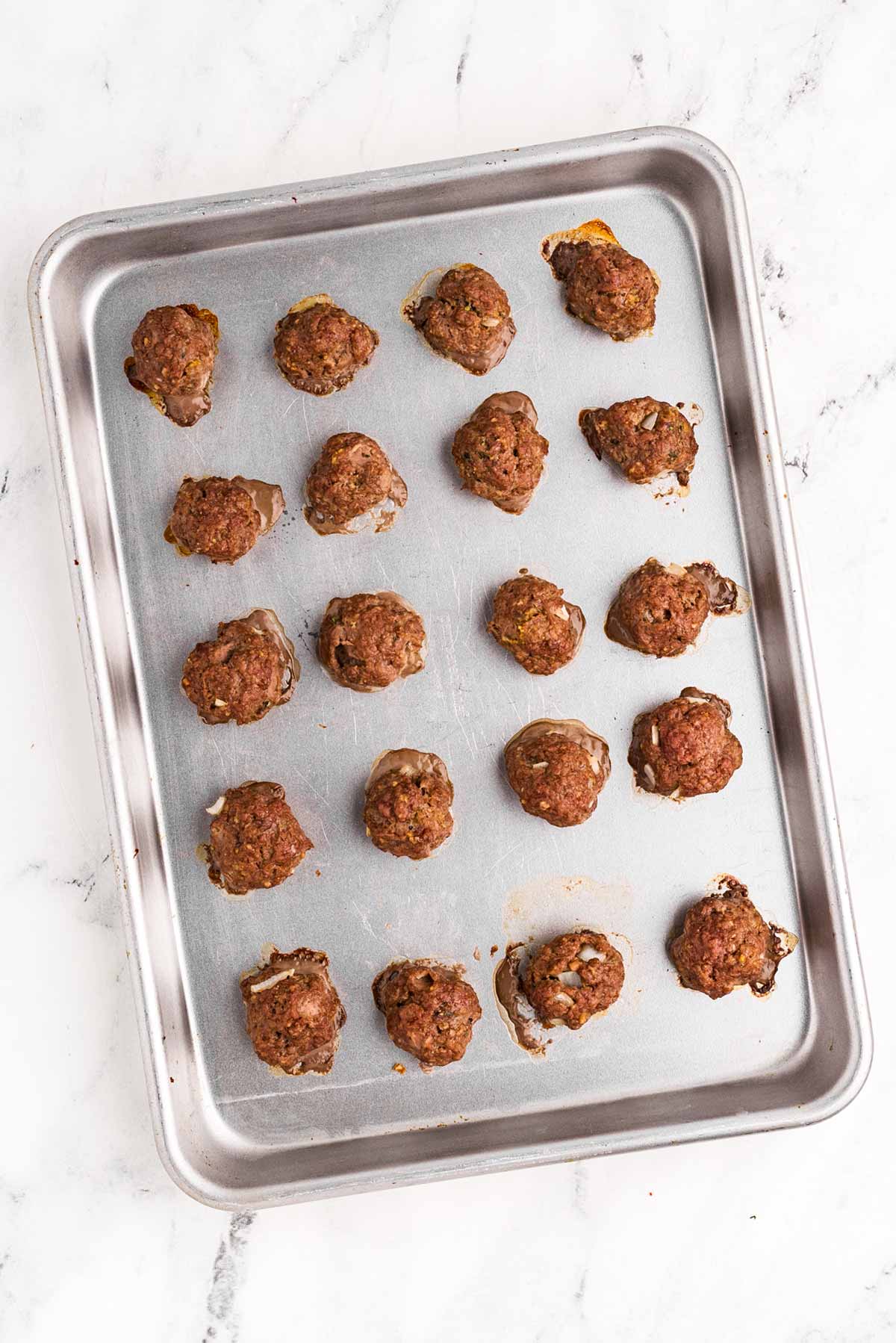 overhead view of baked meatballs on sheet pan