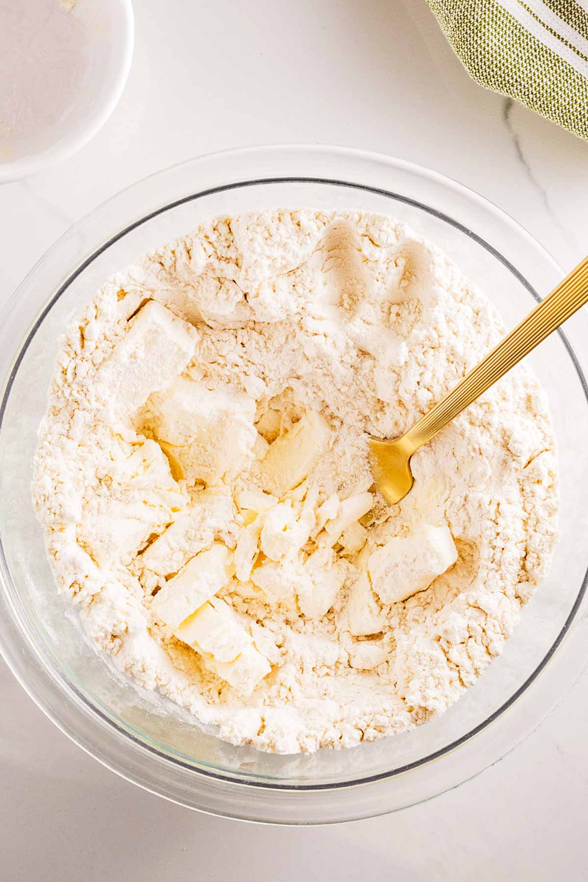 overhead view of flour and butter in glass bowl with spatula