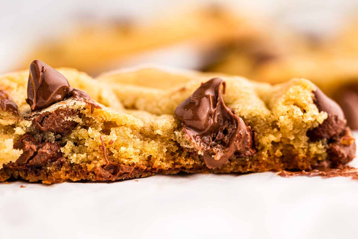 close up photo of broken up chocolate chip cookie with melty chocolate chip