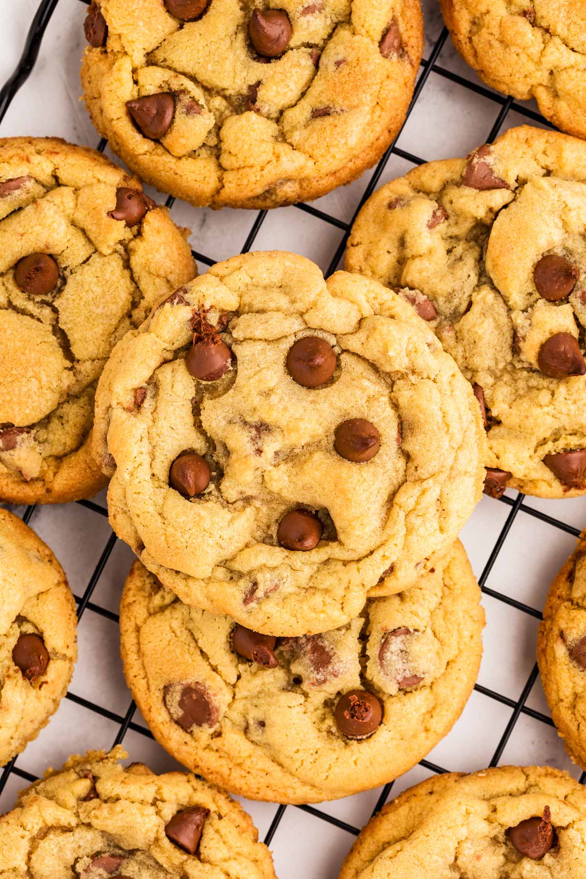 overhead close up view of chocolate chip cookies on black wire rack