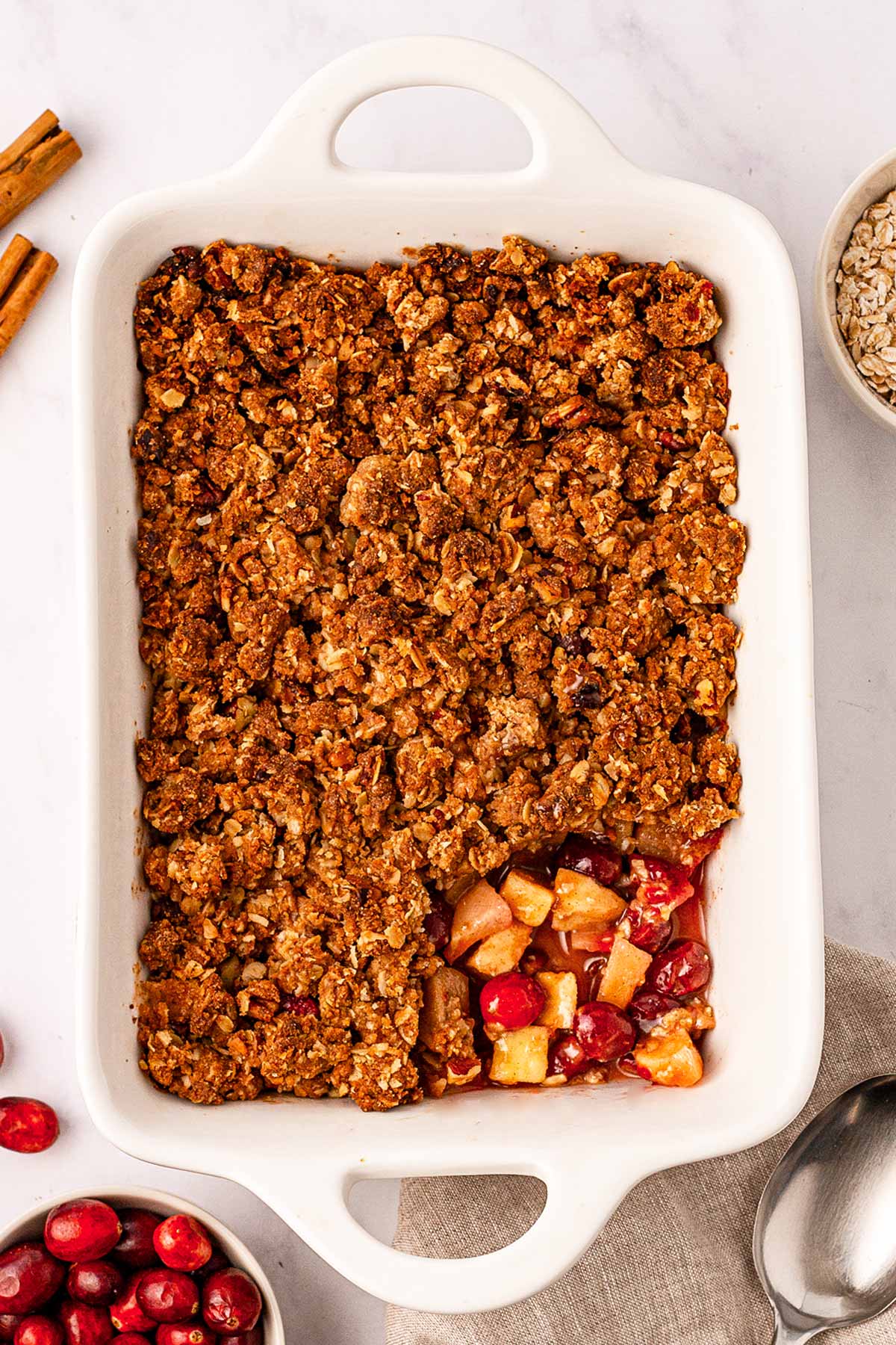 overhead view of baked cranberry apple crisp with spoonful taken out