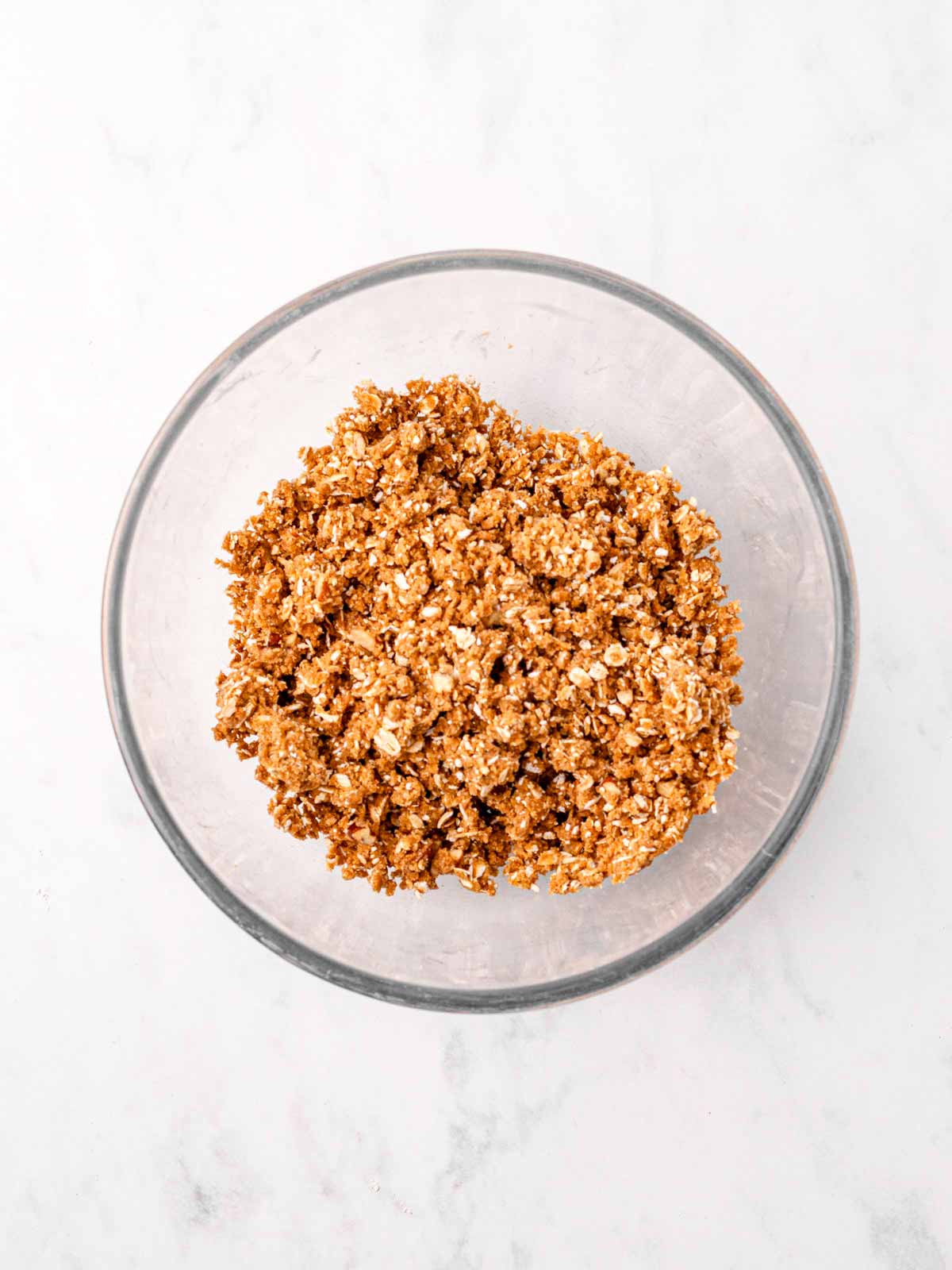 overhead view of oat crumble topping in glass bowl