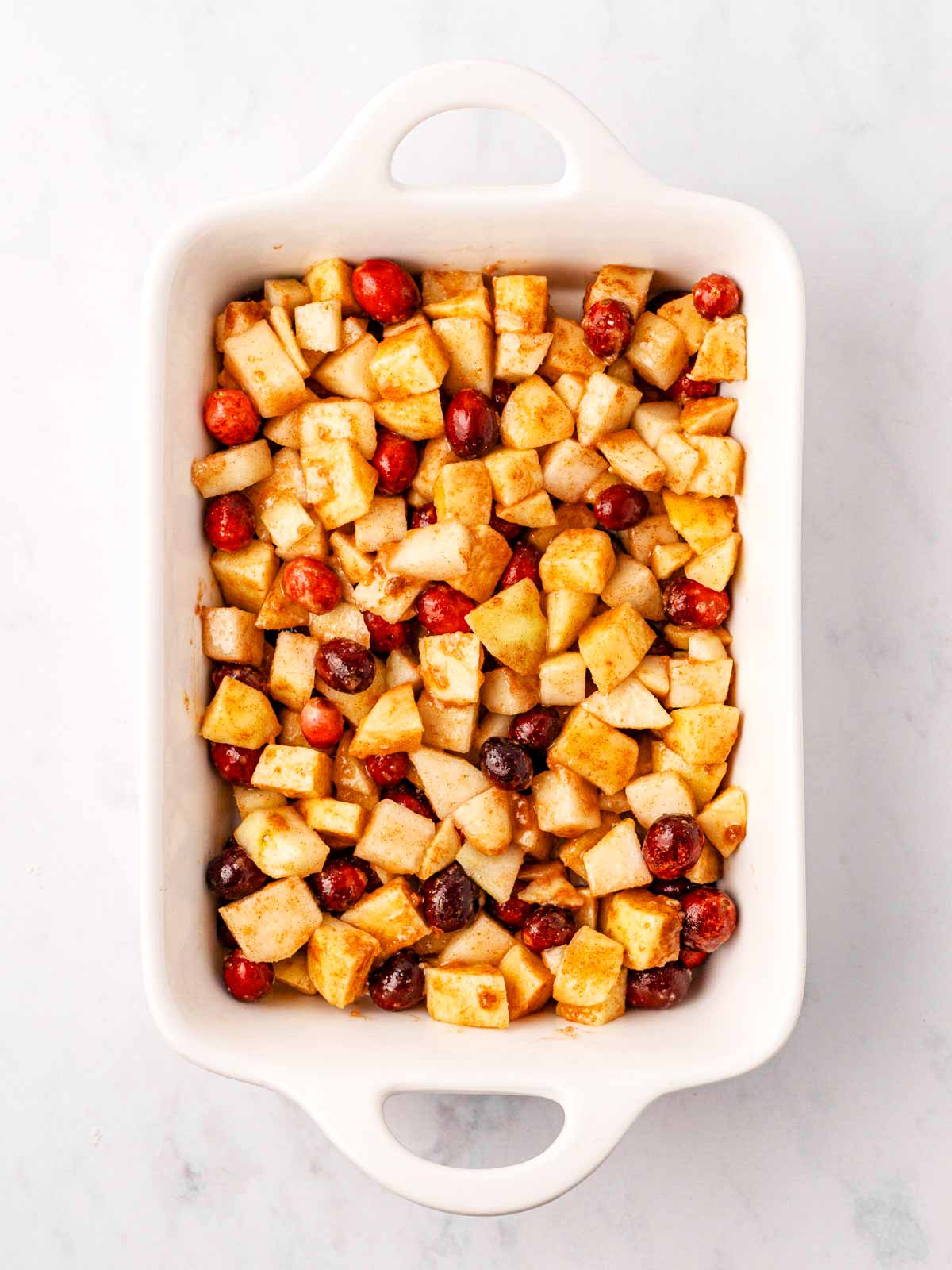 overhead view of cranberry apple crisp filling in rectangular white baking dish