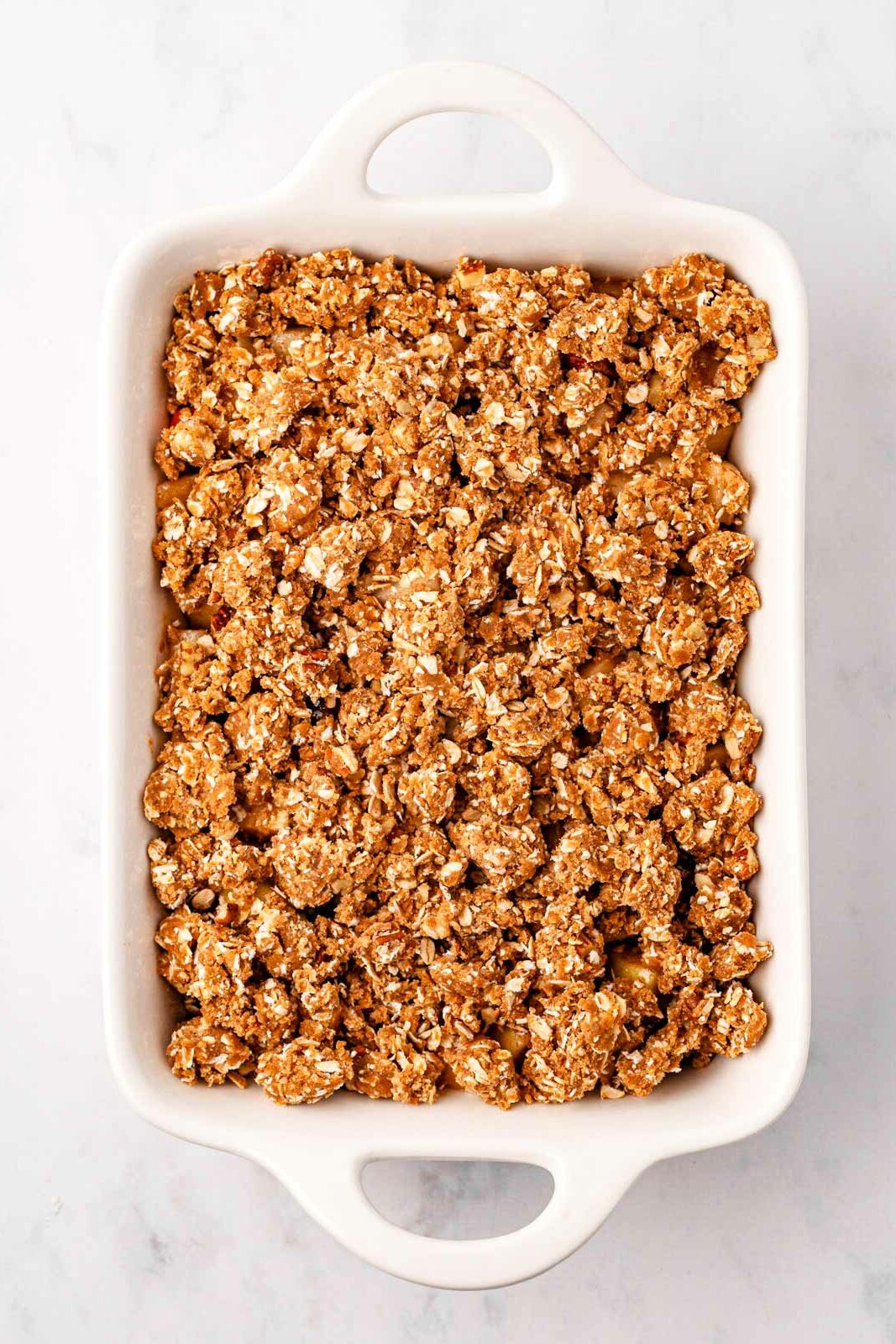 overhead view of unbaked cranberry apple crisp in rectangular white baking dish