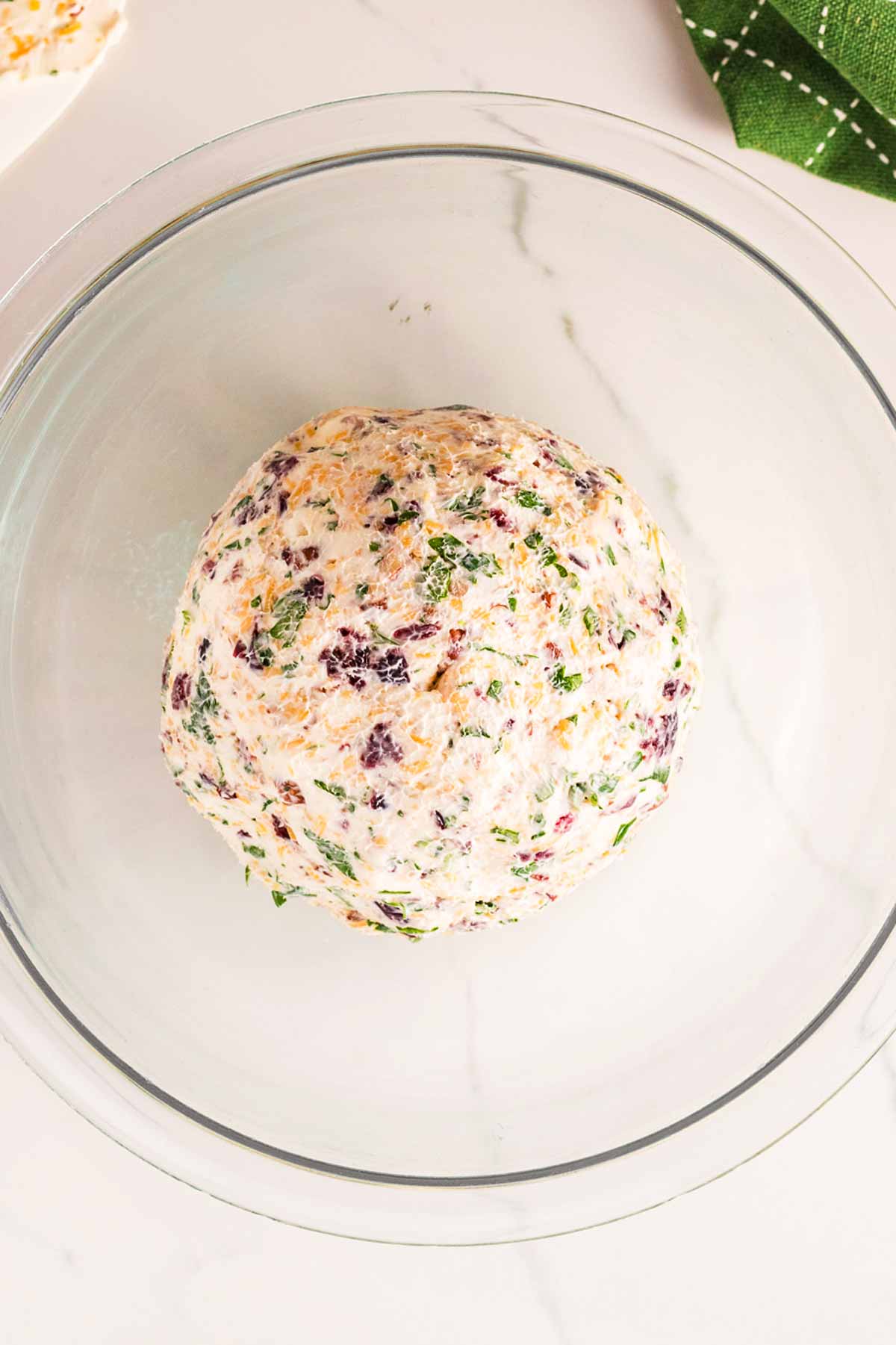 overhead view of cheeseball without toppings in glass bowl