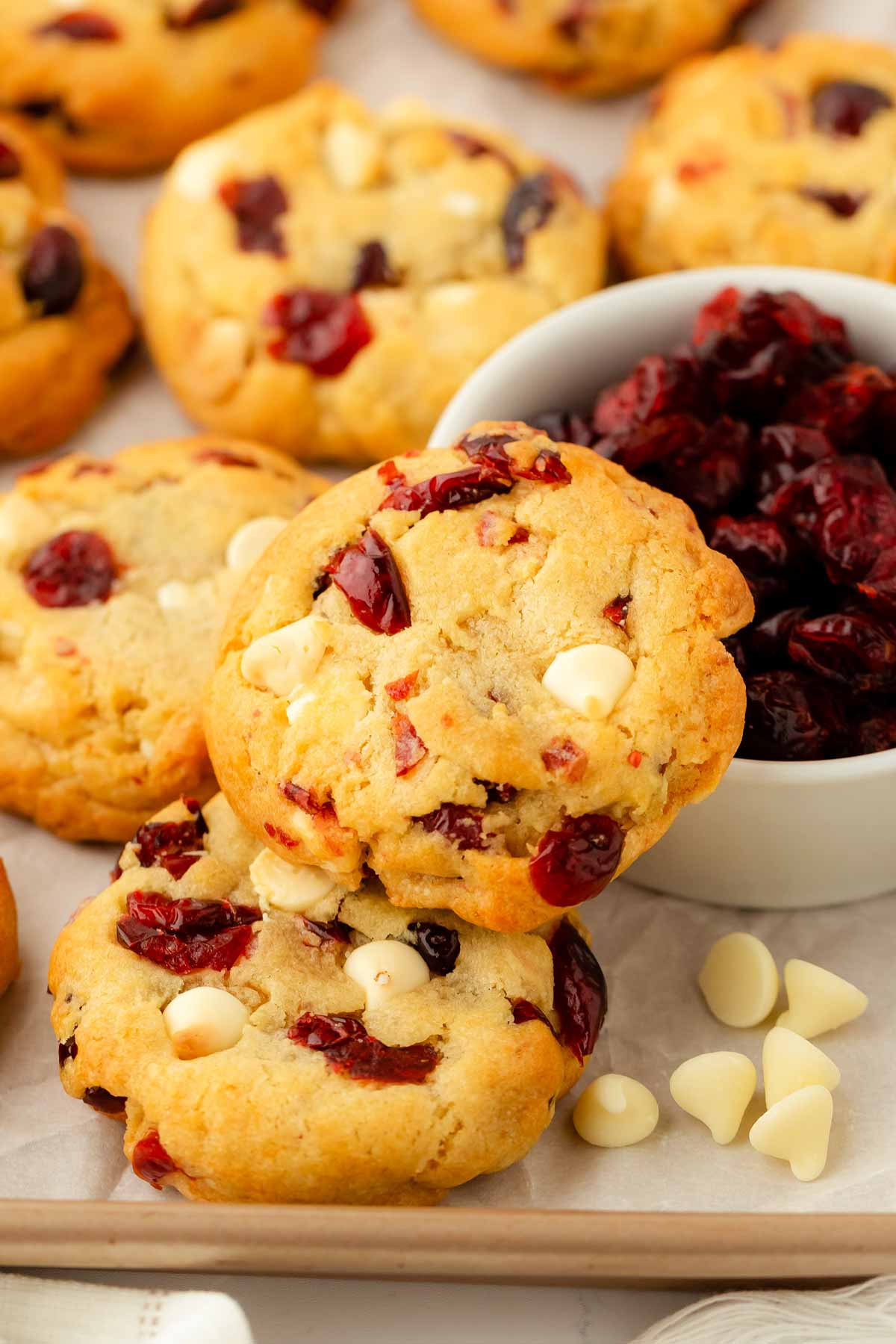 frontal view of cookies on sheet pan with white chocolate chips and dried cranberries