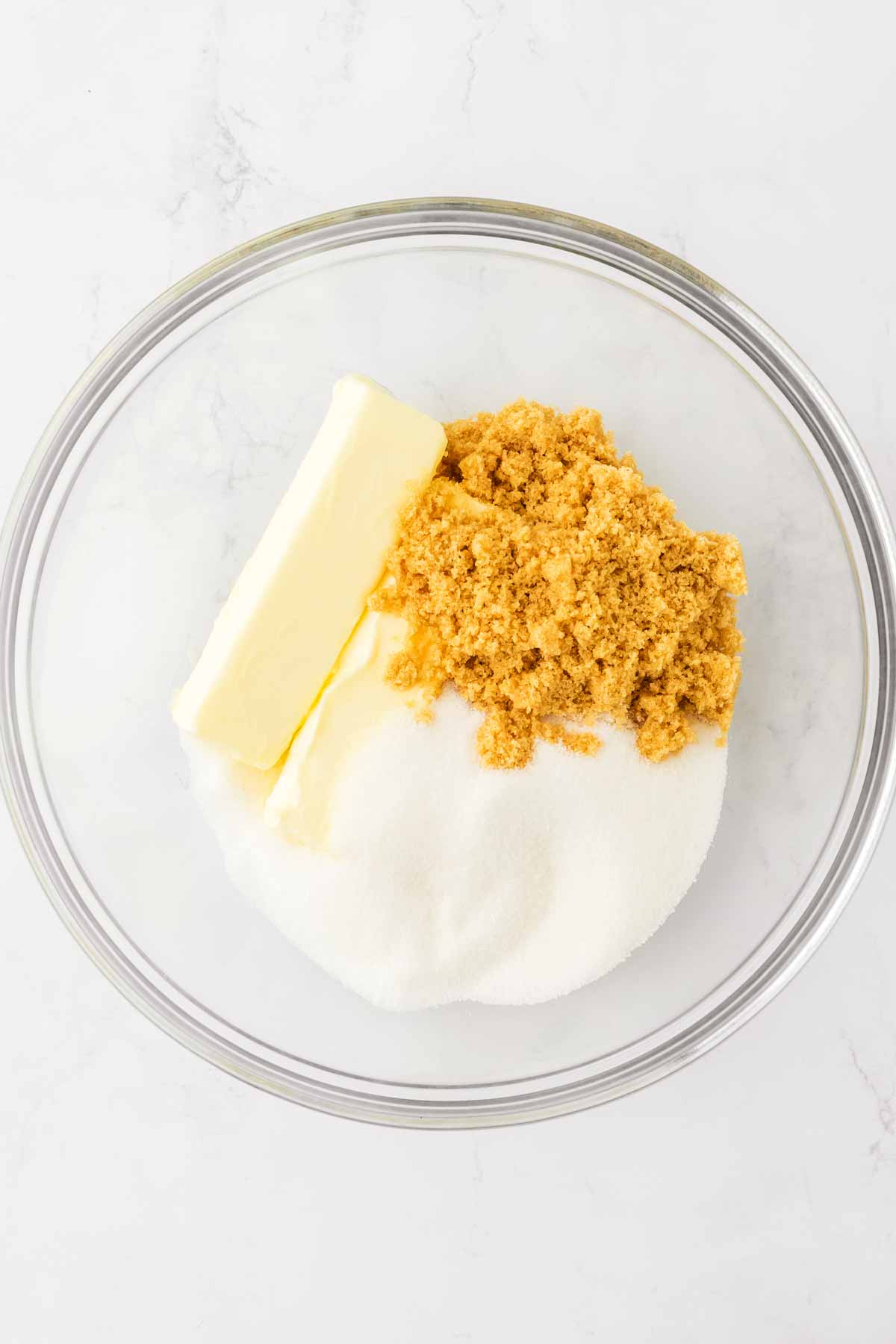 overhead view of butter and sugar in glass bowl