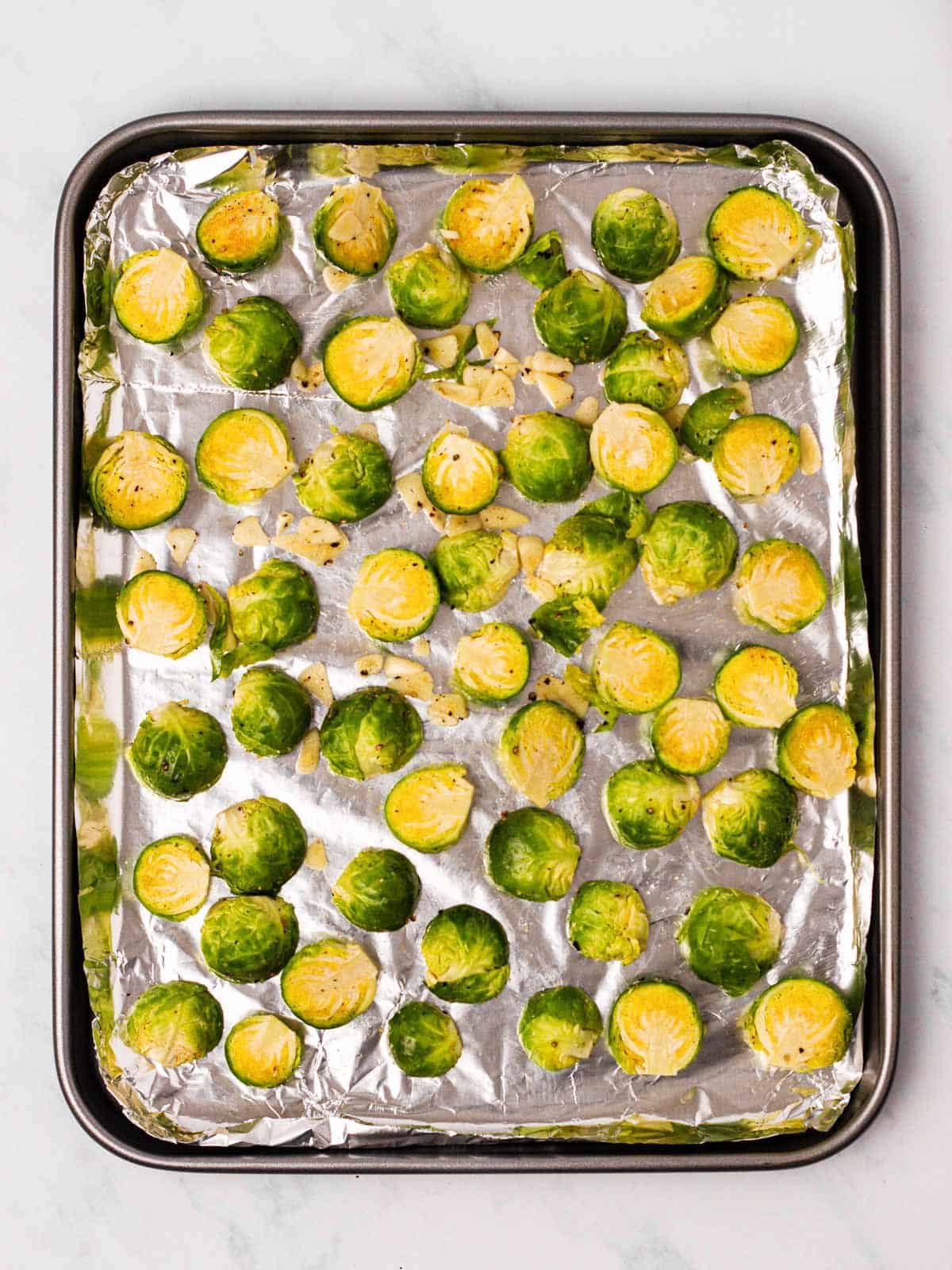 overhead view of raw Brussels sprouts on foil lined sheet pan